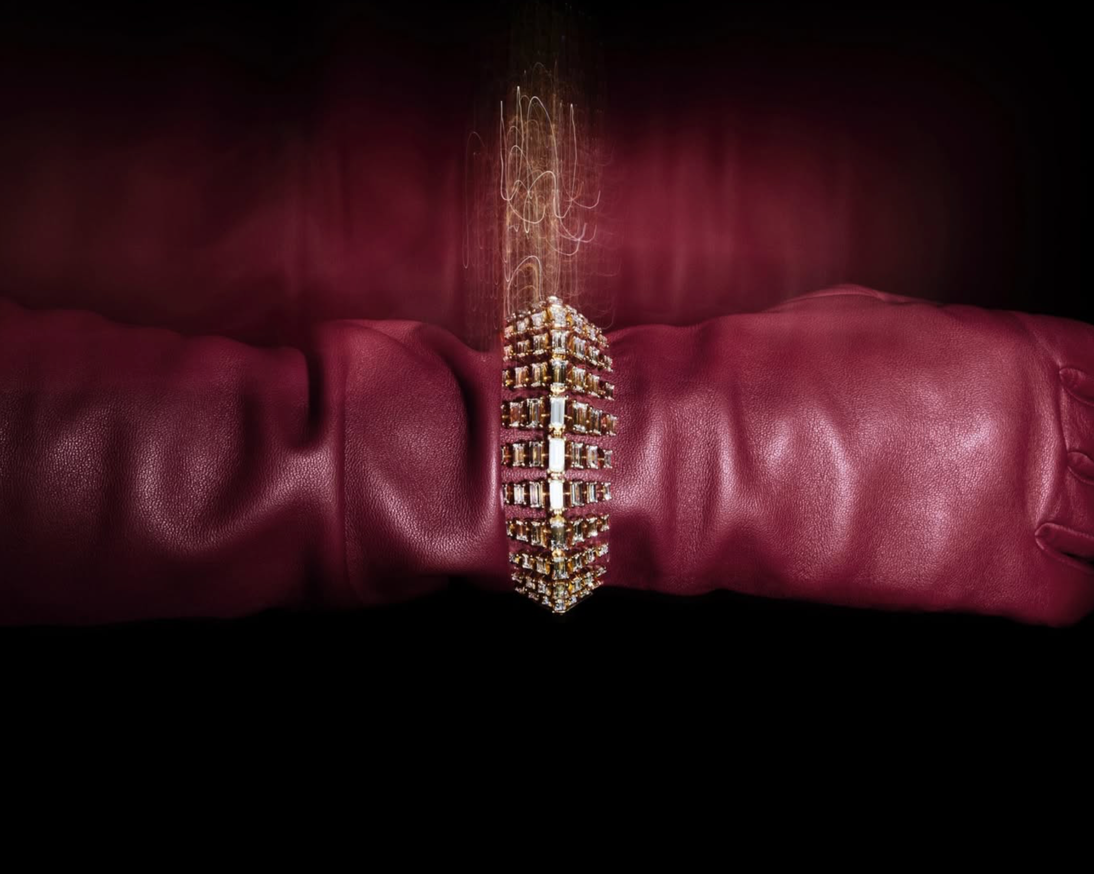 Jewelled pendant resting on folds of deep red leather under dramatic light