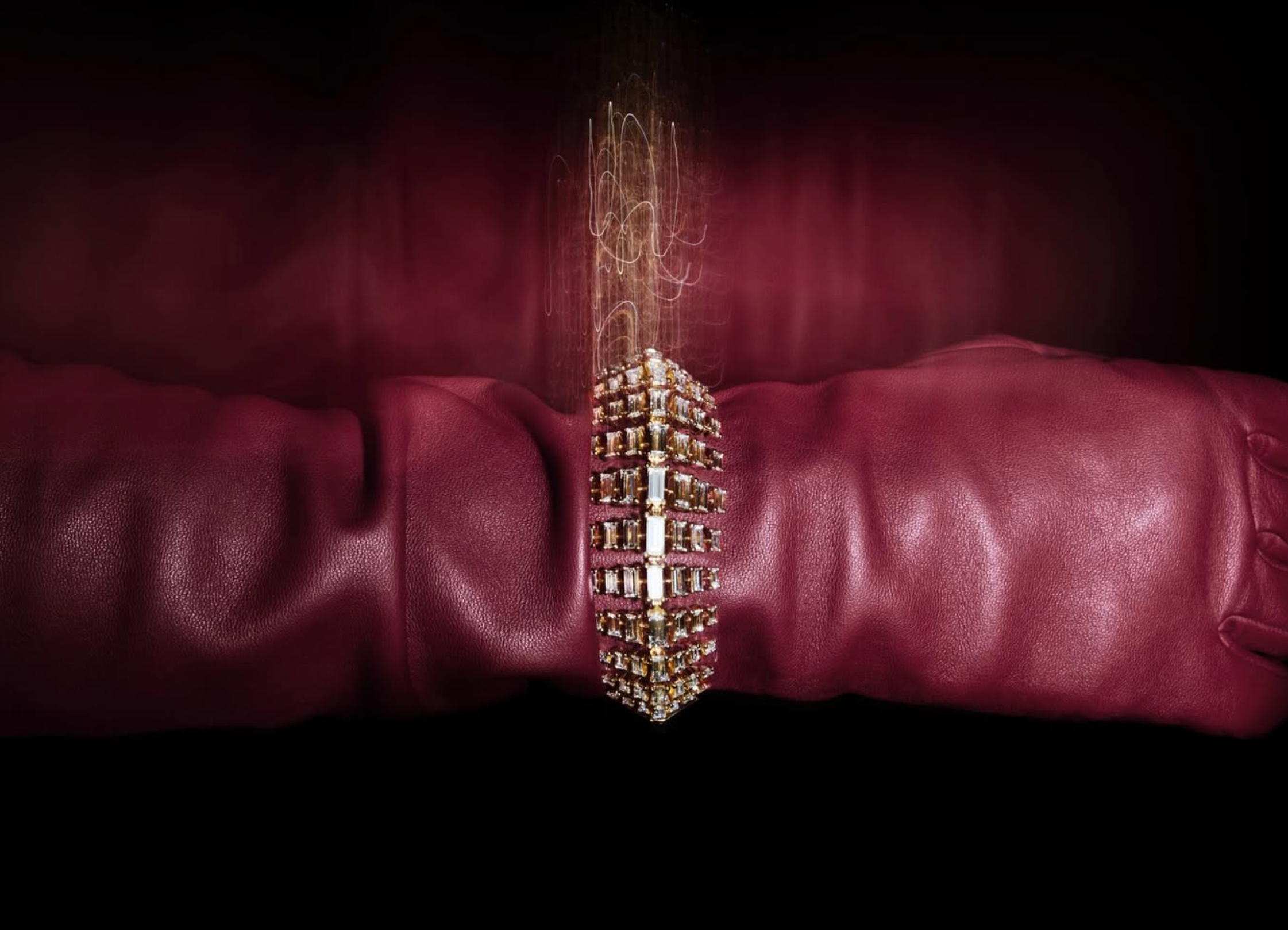 Jewelled pendant resting on folds of deep red leather under dramatic light
