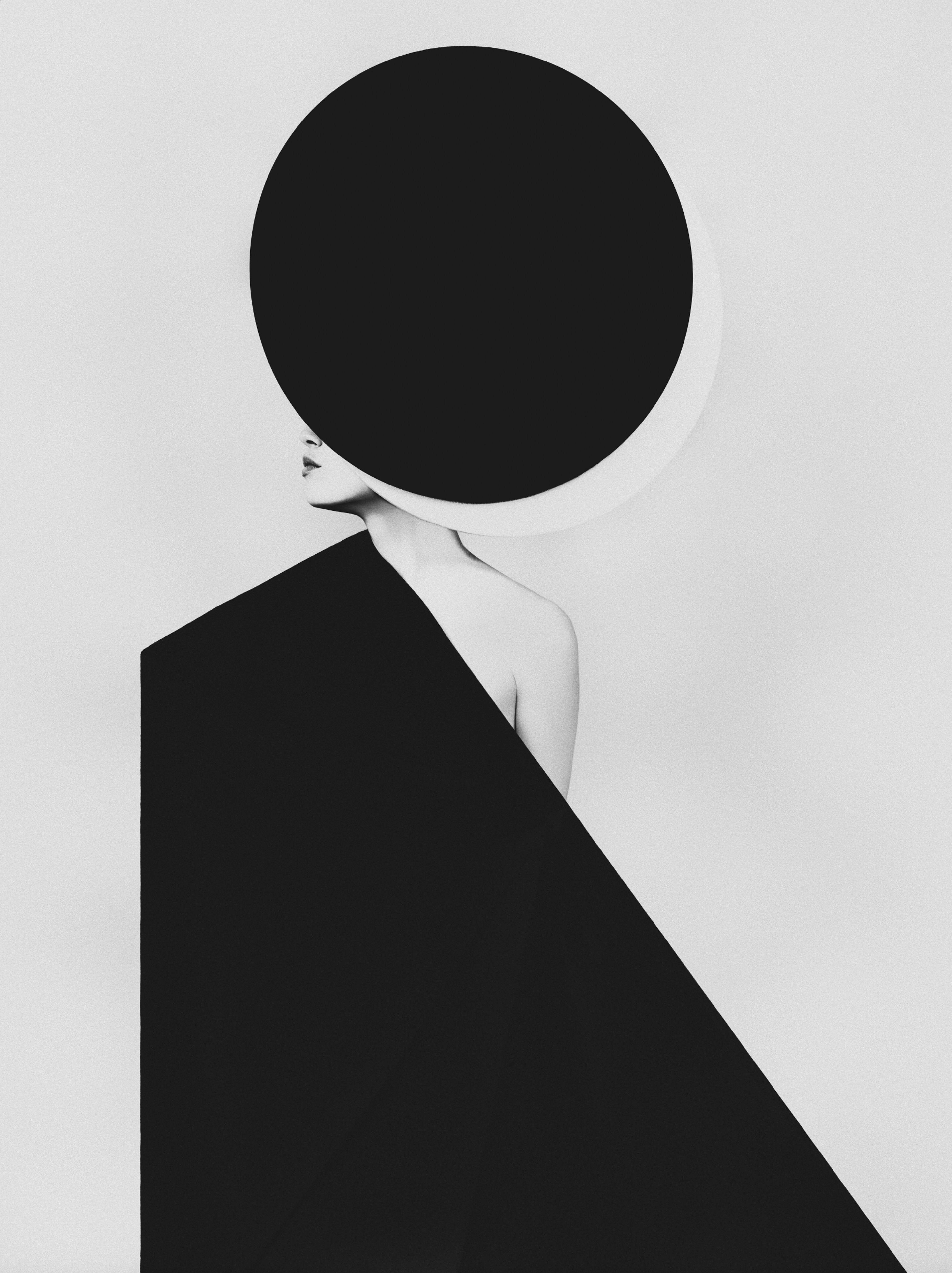 Graphic black-and-white study of a figure beneath an oversized circular hat