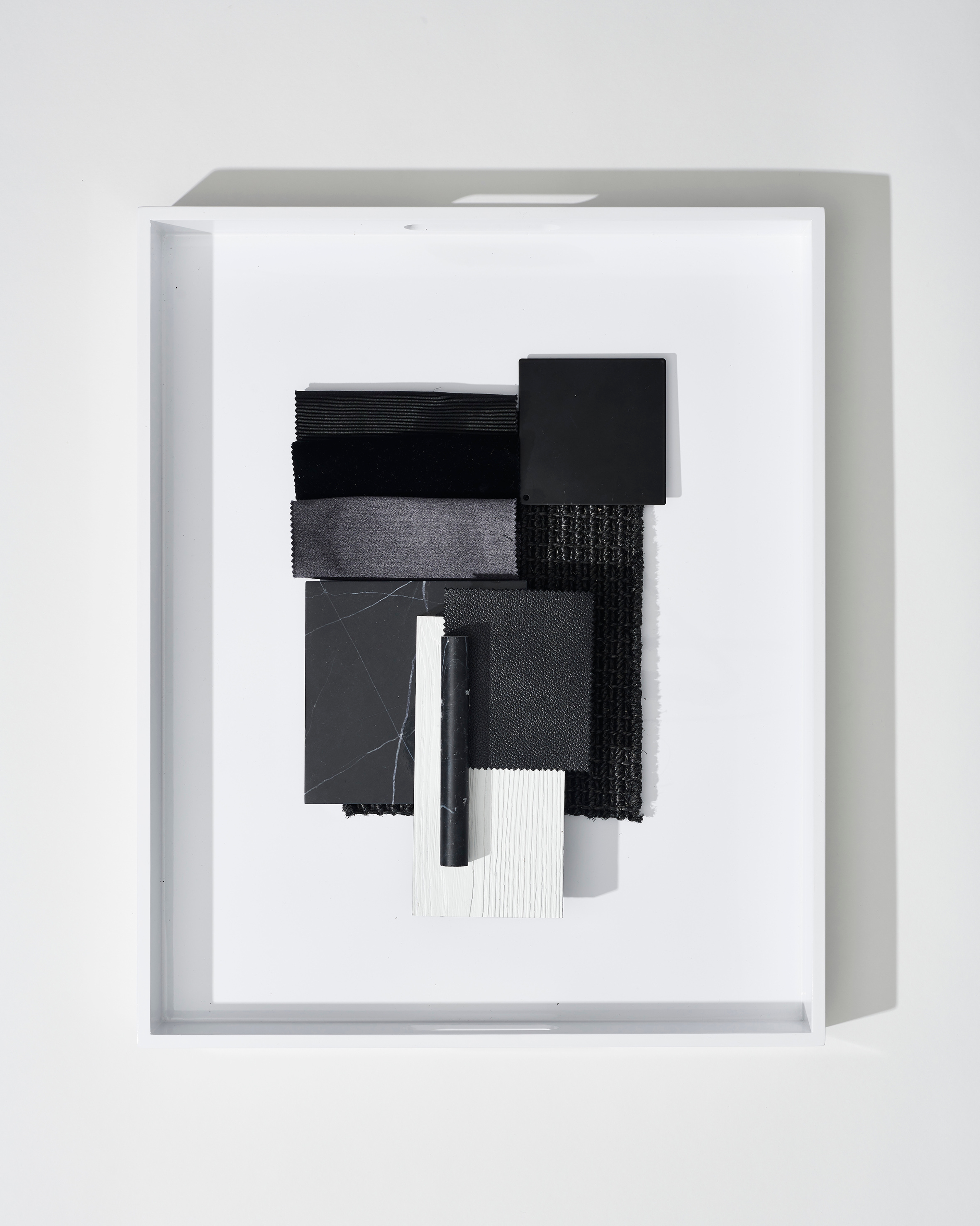 Framed black-and-white assemblage relief floating within a deep shadow box