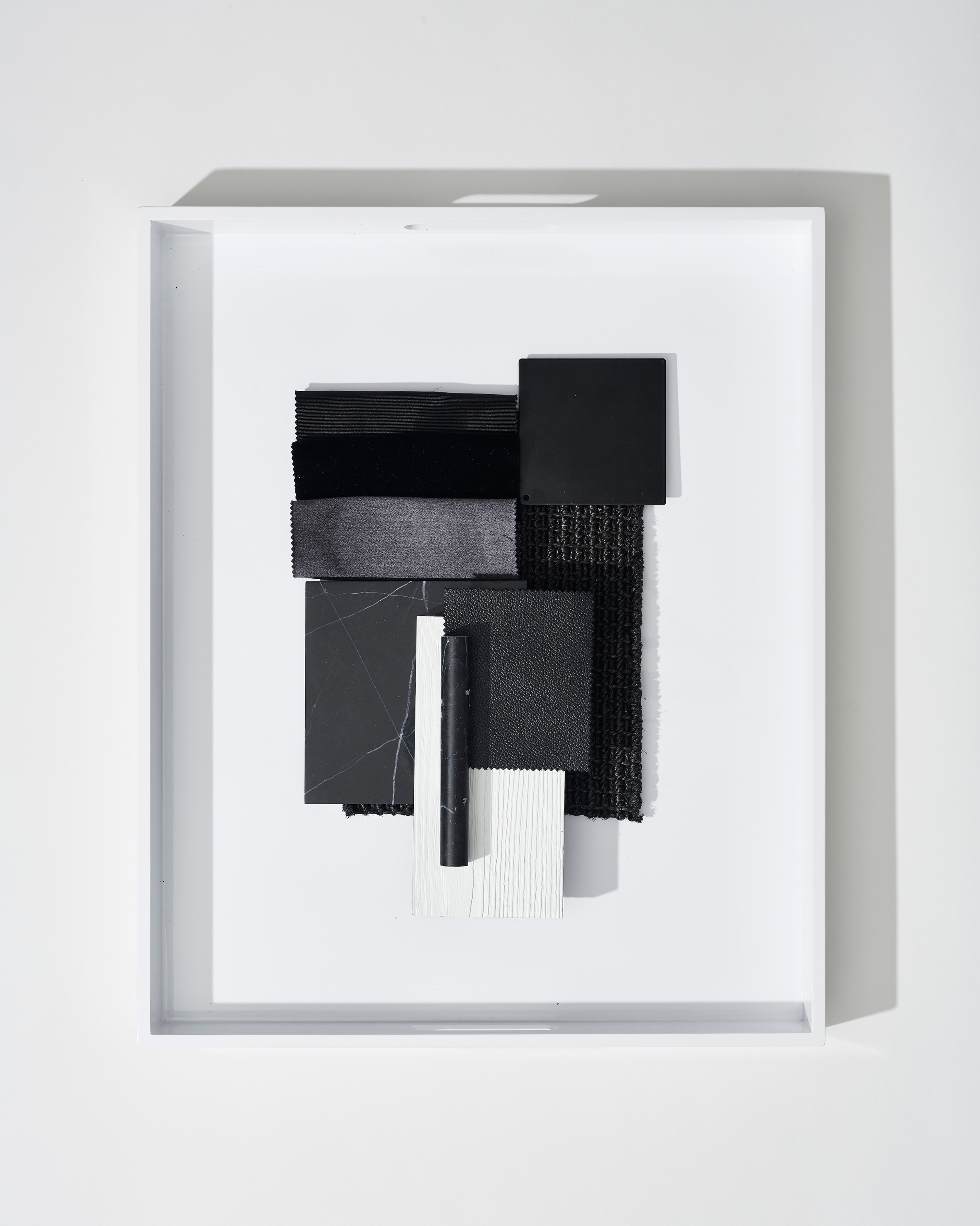 Framed black-and-white assemblage relief floating within a deep shadow box