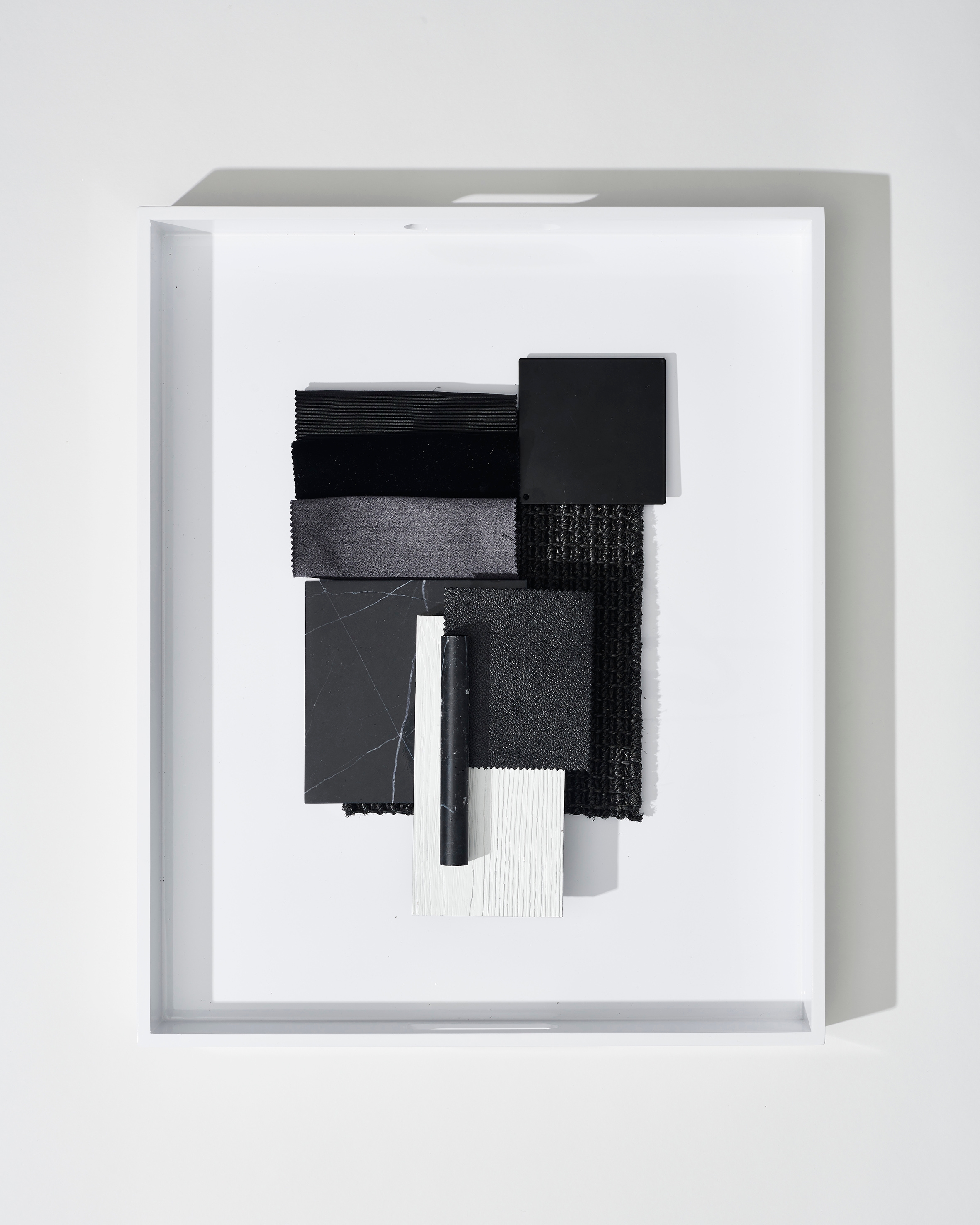 Framed black-and-white assemblage relief floating within a deep shadow box