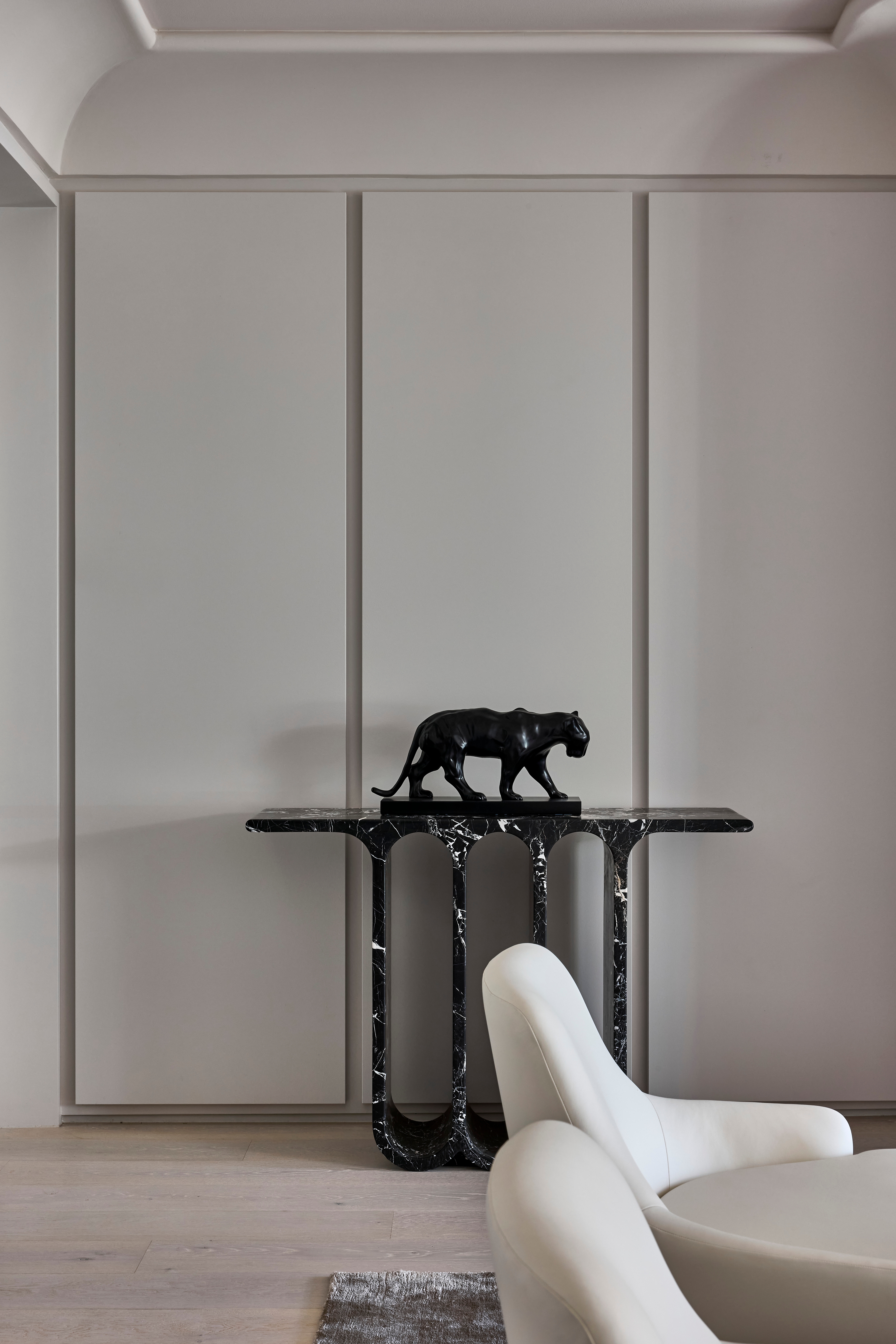 Panelled room, Jack Freeman-designed, pairing a black velvet wingback with marble surrounds and a bust