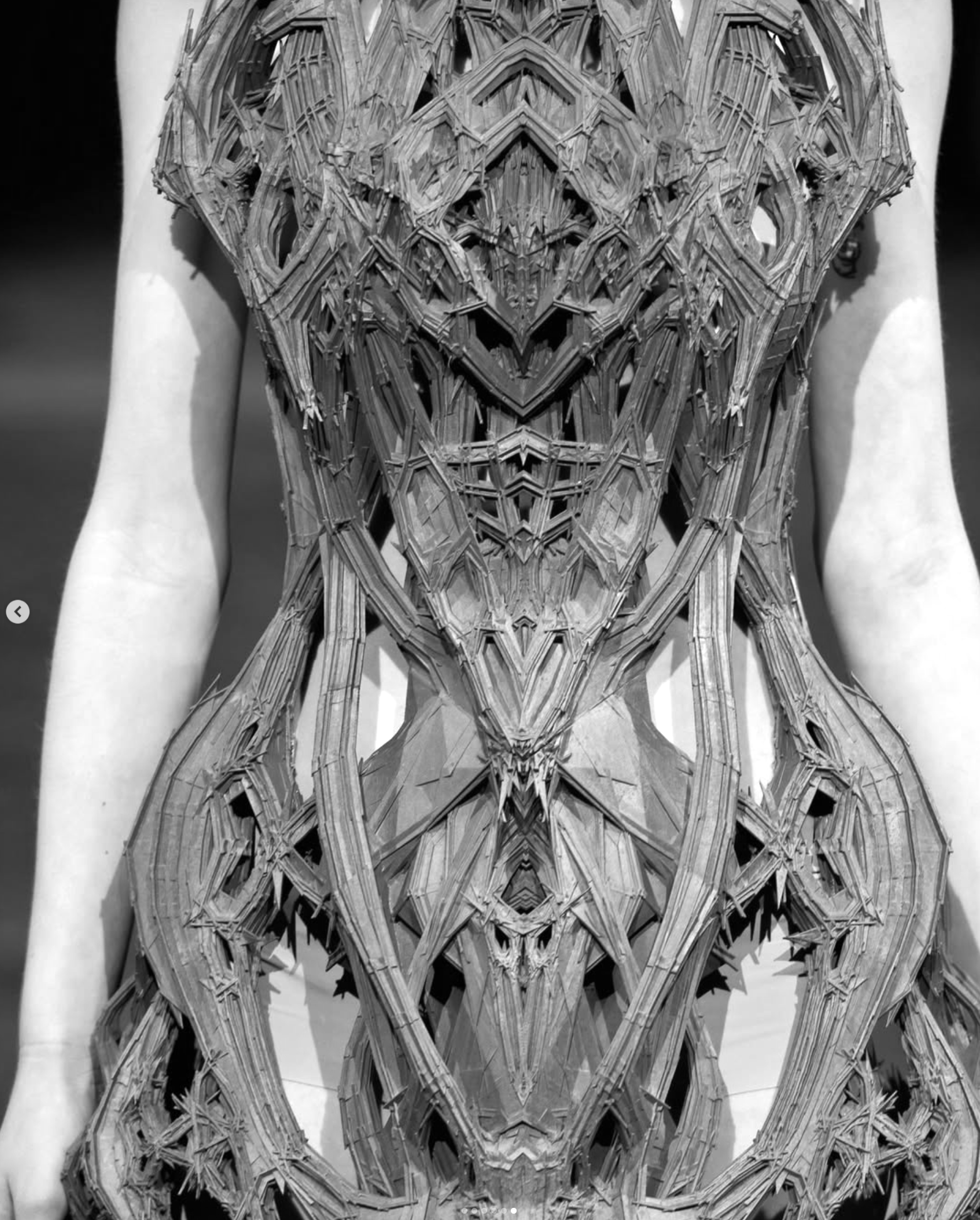 Intricately laser-cut sculptural bodice by Iris van Herpen, shown close in black and white