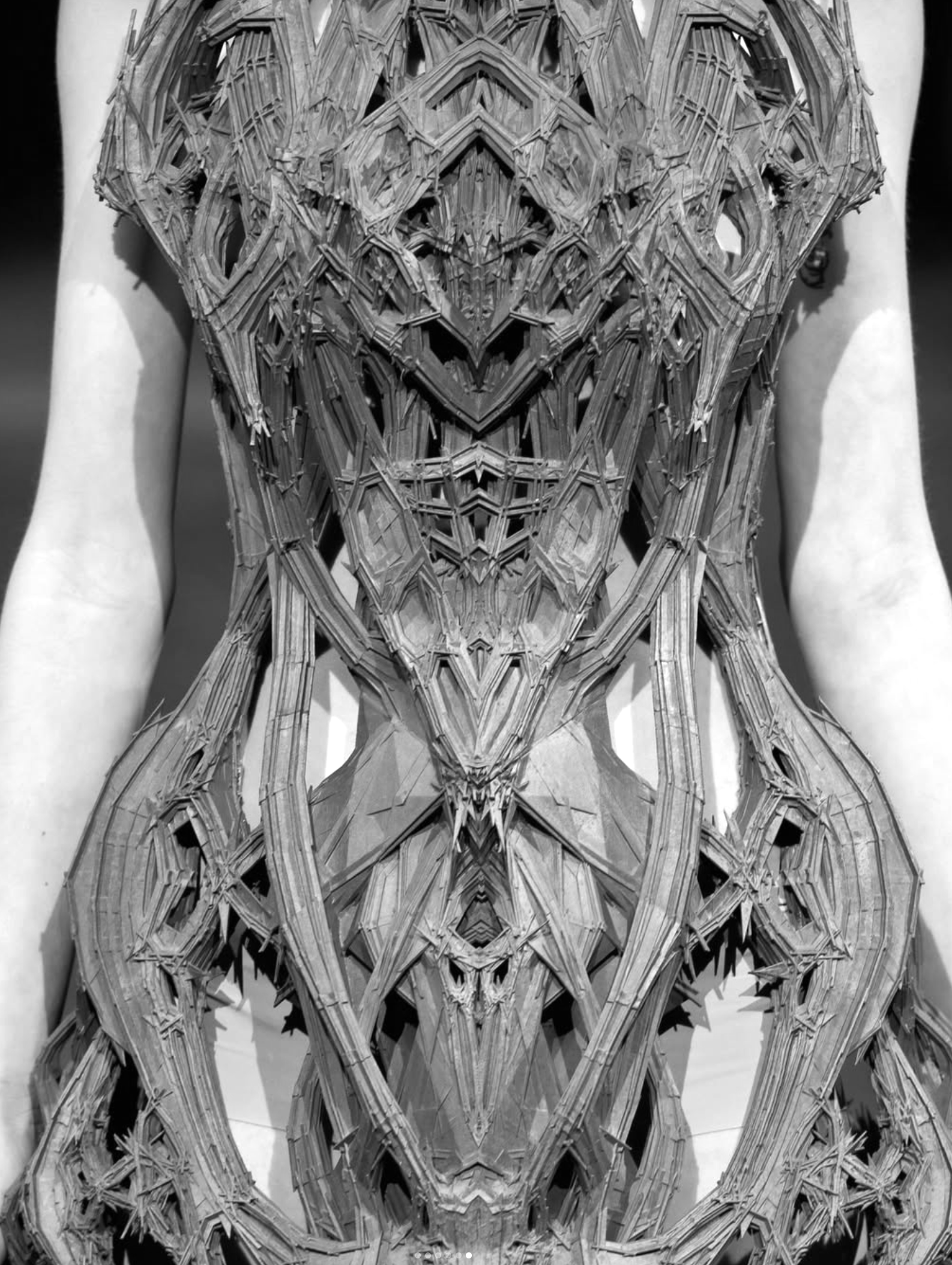 Intricately laser-cut sculptural bodice by Iris van Herpen, shown close in black and white