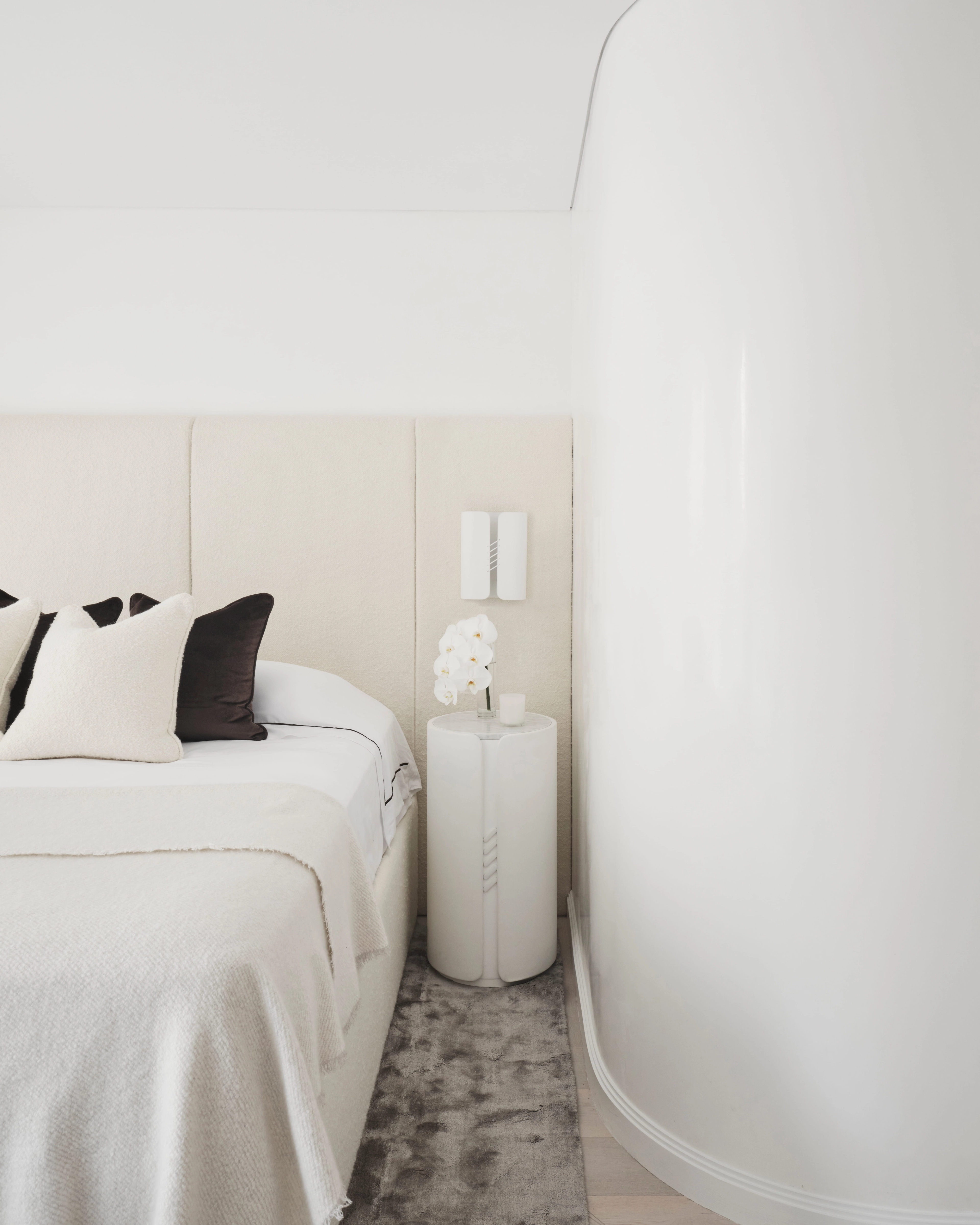 Elizabeth Bay bedroom with an upholstered headboard, crisp linens and a round pedestal side table