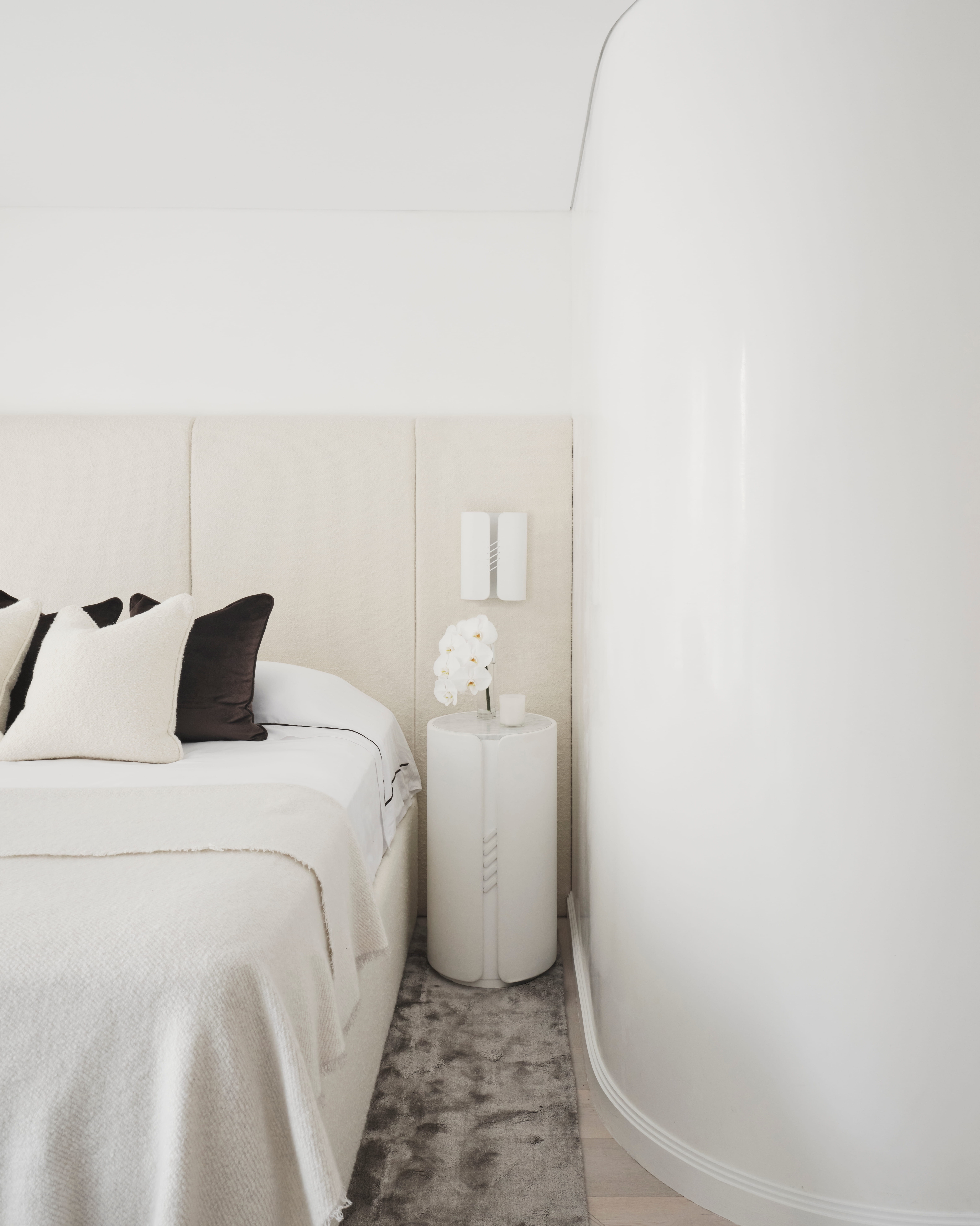 Elizabeth Bay bedroom with an upholstered headboard, crisp linens and a round pedestal side table