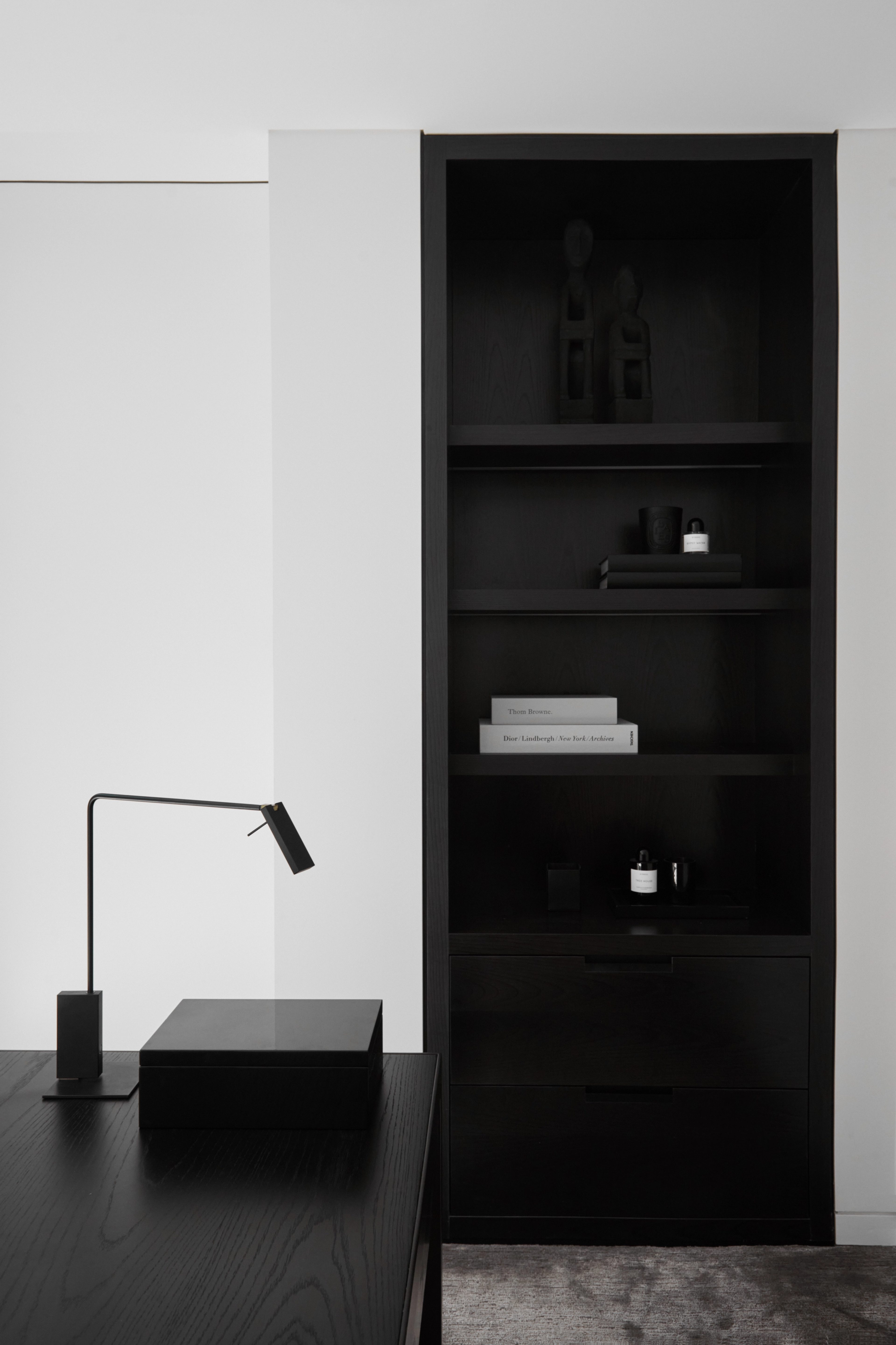 Moody Balmoral Beach study with black built-in shelving, a matte desk and slim task lamp