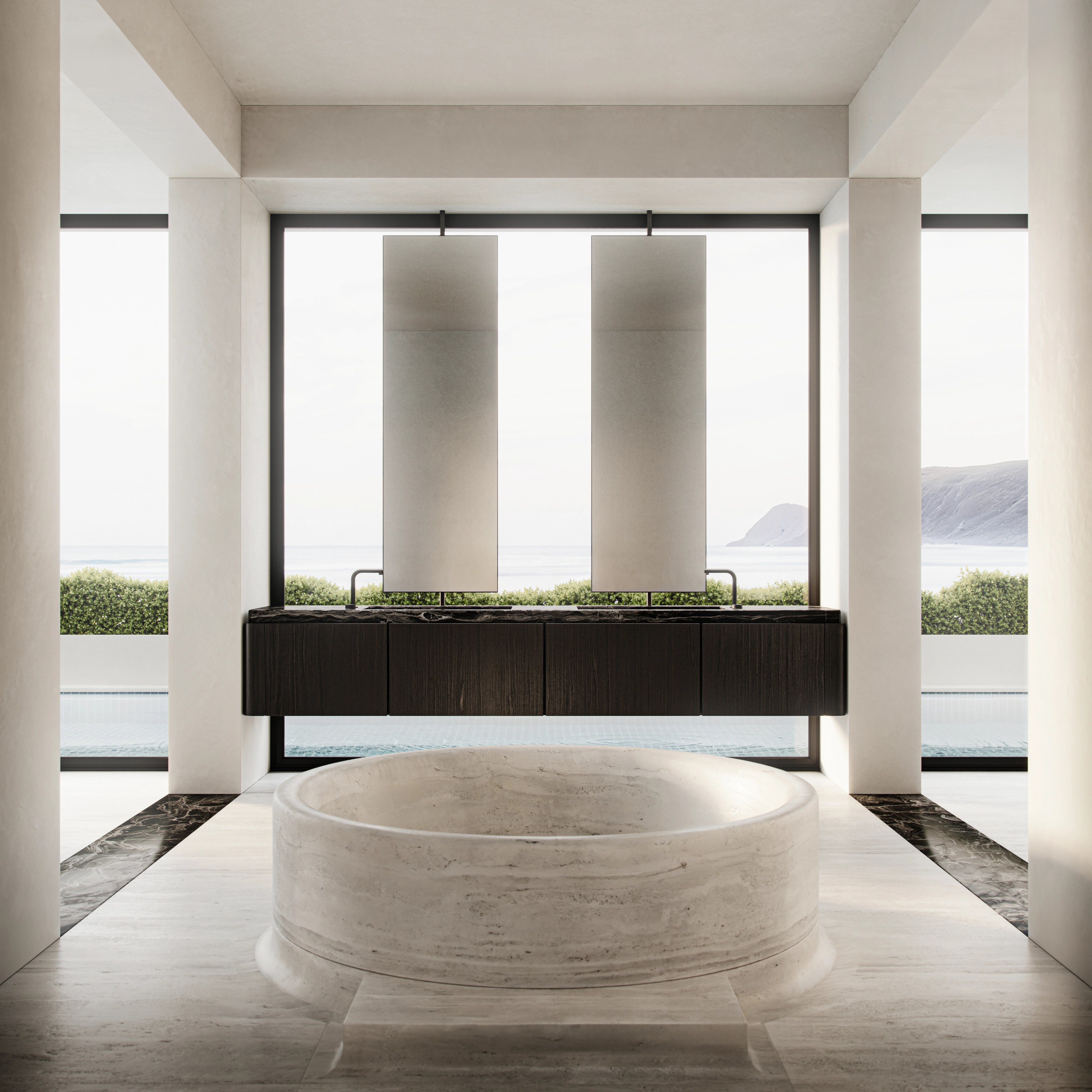 Round stone bath framed by floor-to-ceiling ocean views on the South Coast