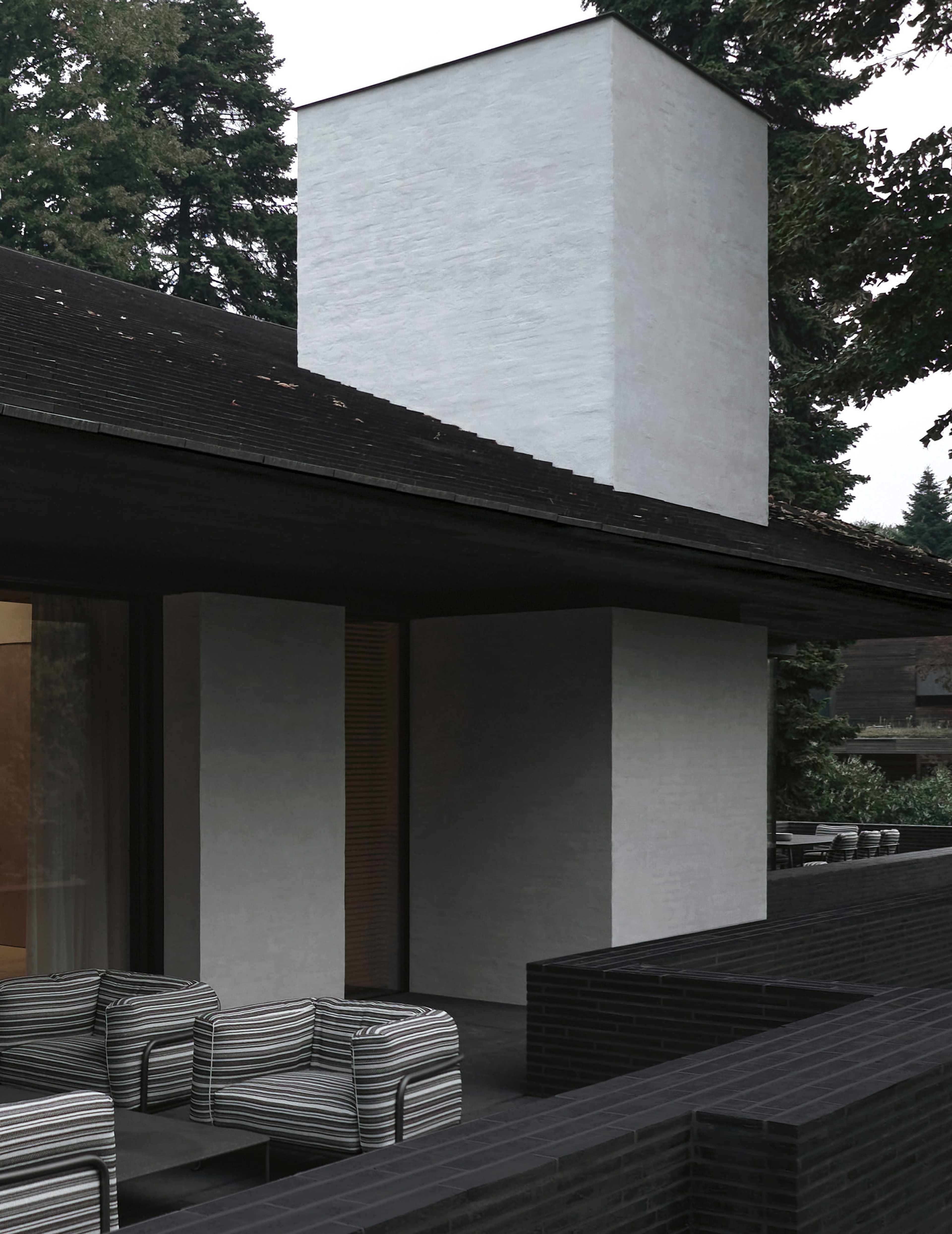 Minimalist rendered-and-brick house with a shaded terrace, designed by Vincent Van Duysen