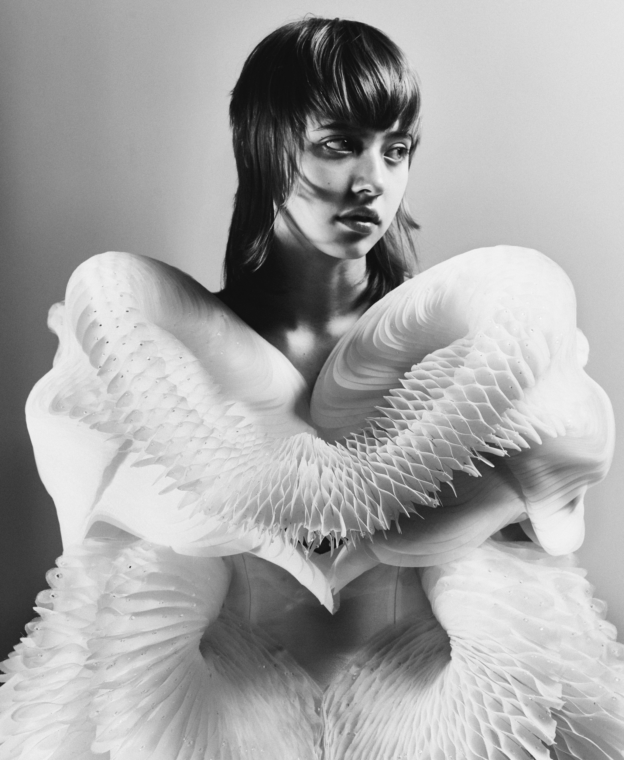 Iris van Herpen's honeycomb-pleated gown modelled arms-crossed in stark black and white