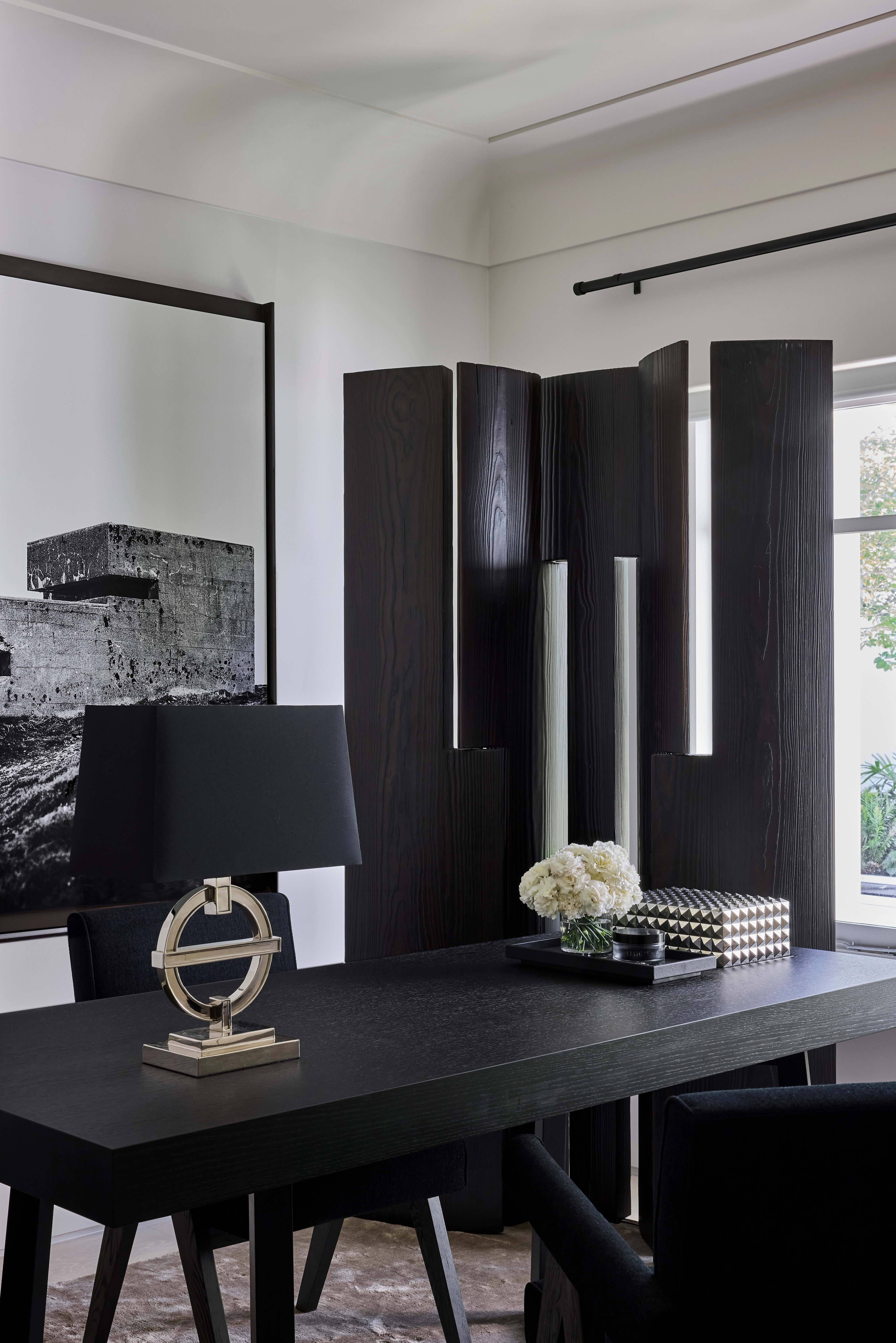 Jack Freeman-designed home office with a black desk, folding screen and monochrome artwork
