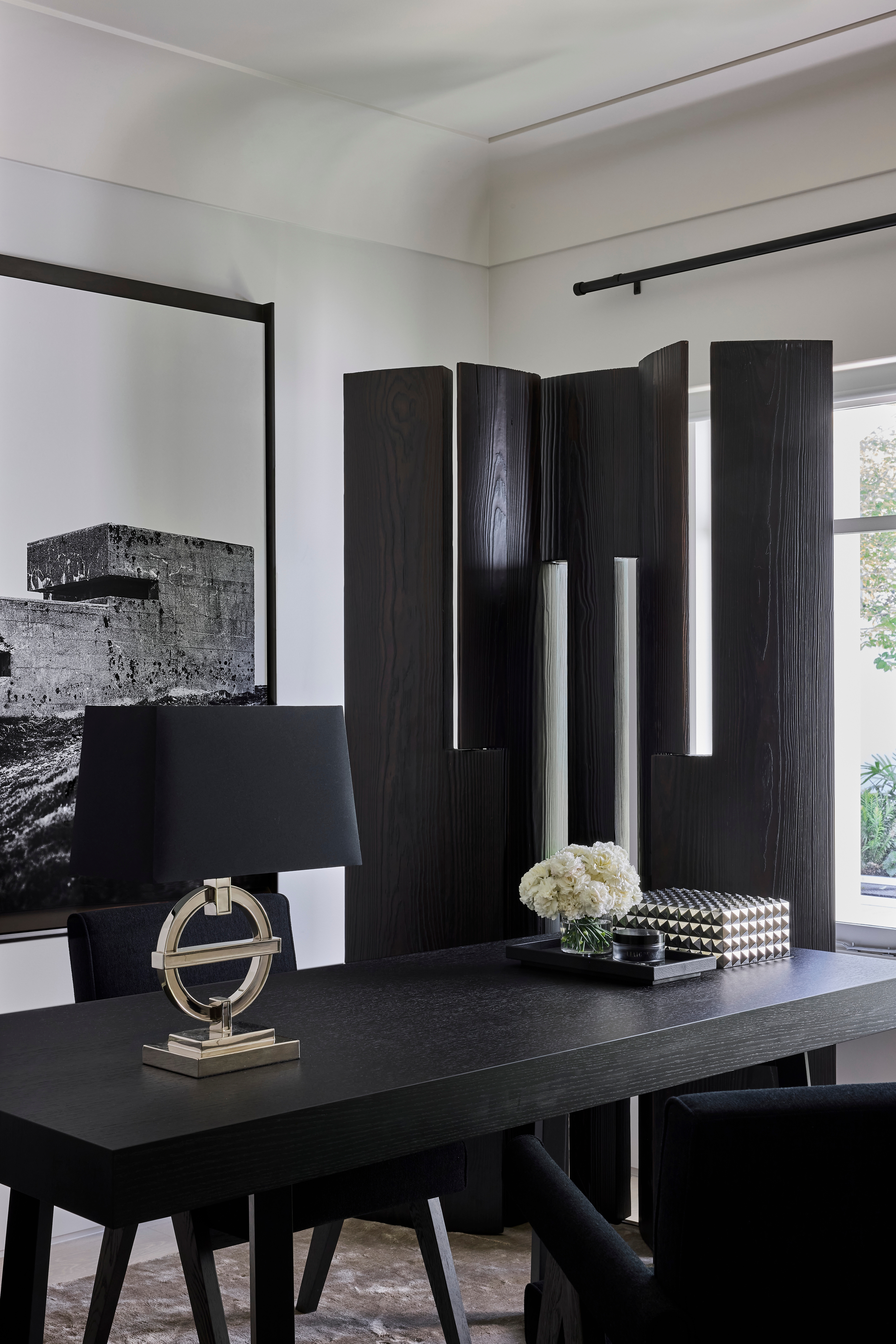 Jack Freeman-designed home office with a black desk, folding screen and monochrome artwork