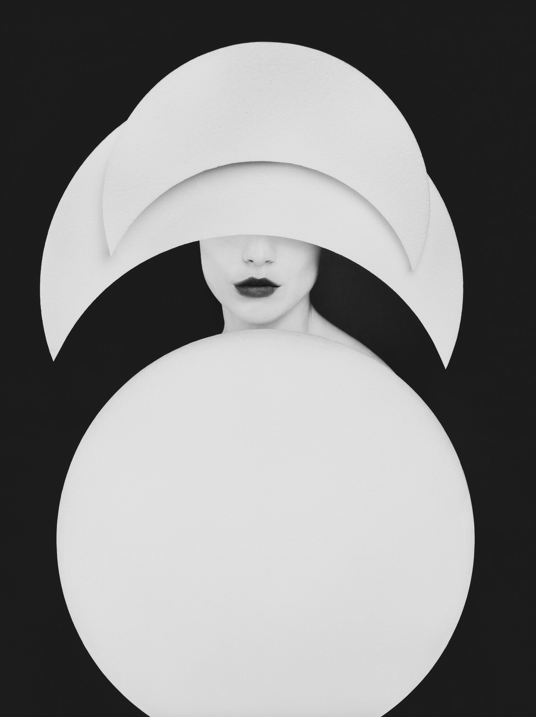 Bastiaan Woudt's high-contrast portrait of a woman beneath a white crescent form and orb