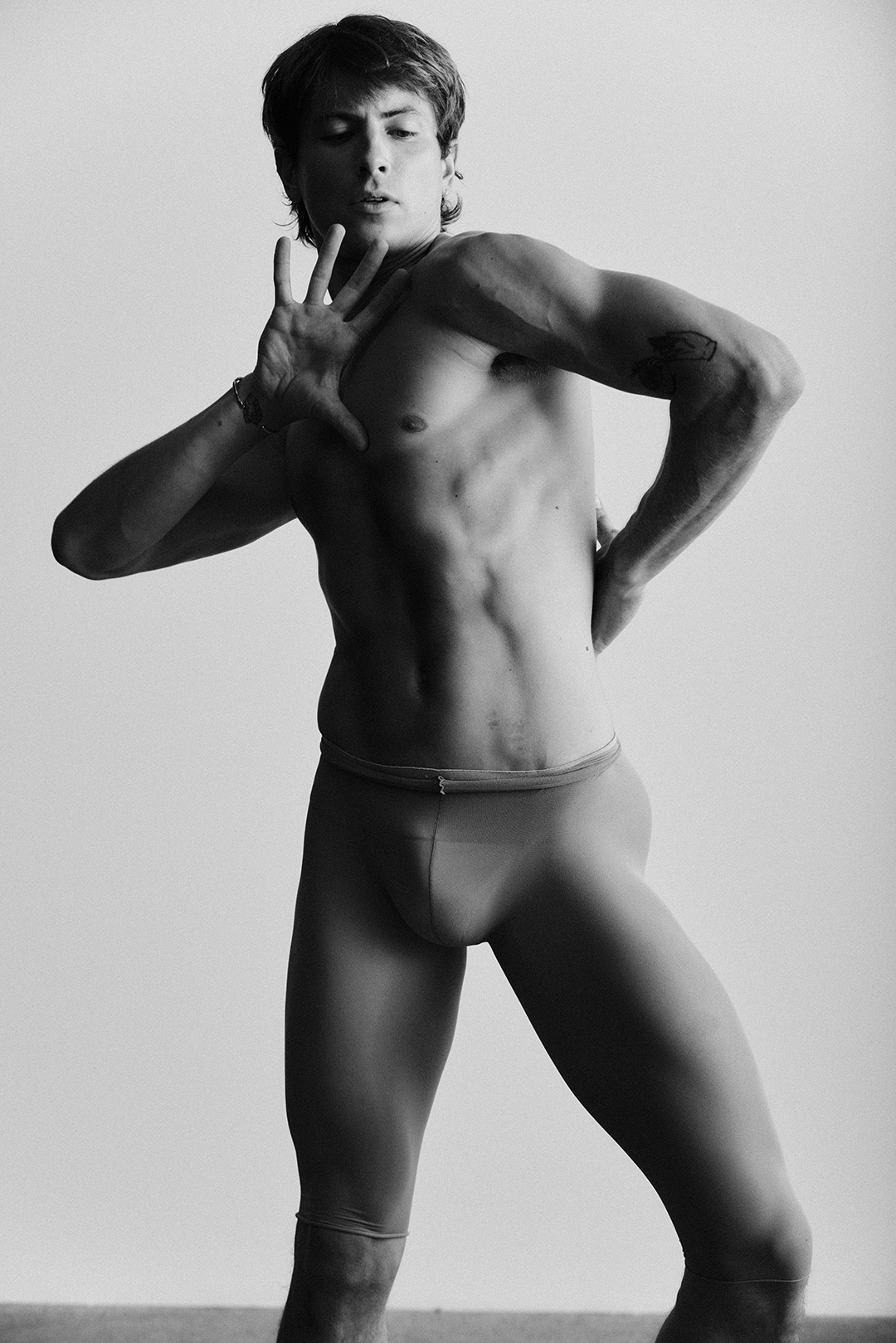 Muscular dancer captured mid-motion in a stark studio study