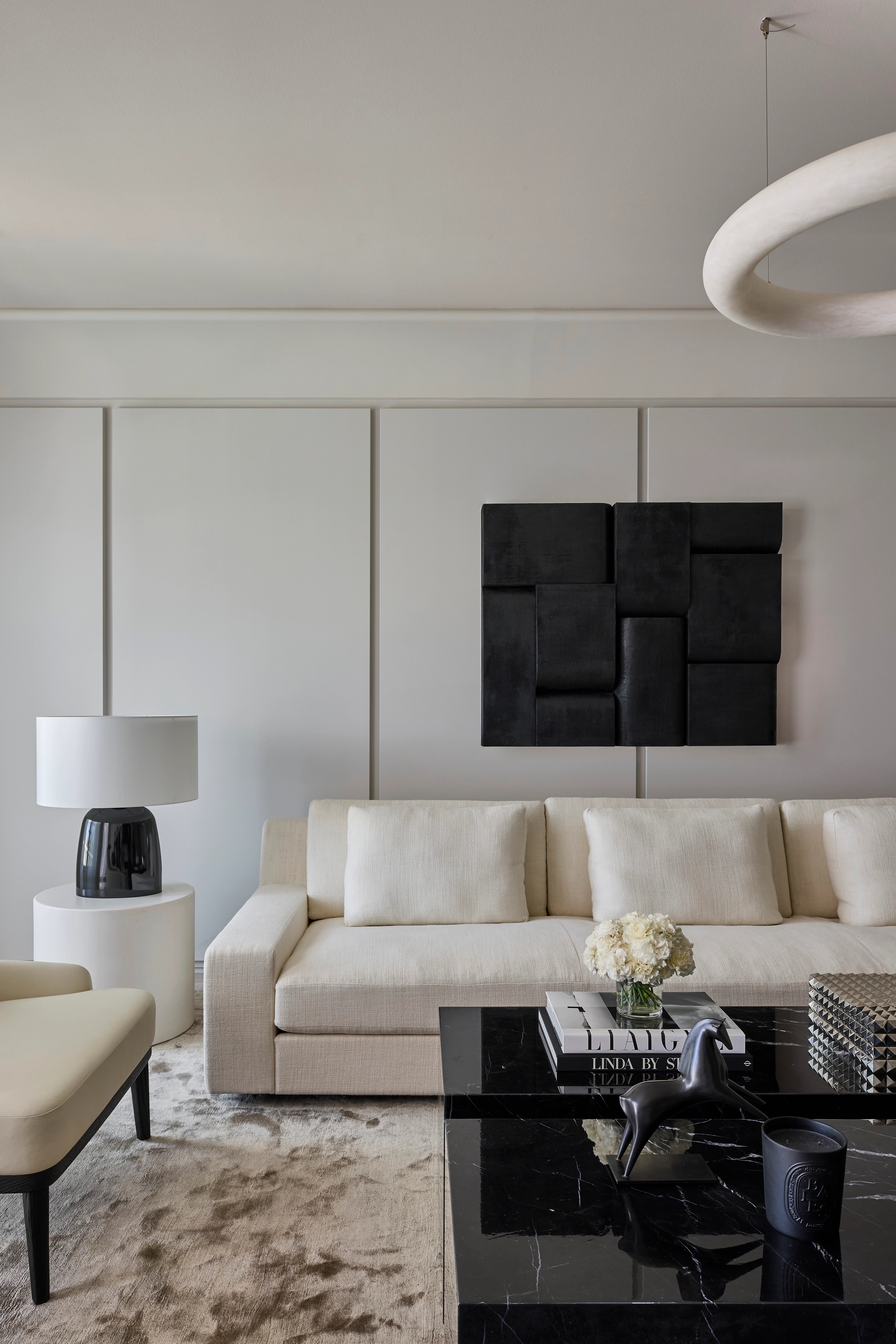 Vincent Van Duysen living room with an ivory sofa and abstract black wall relief