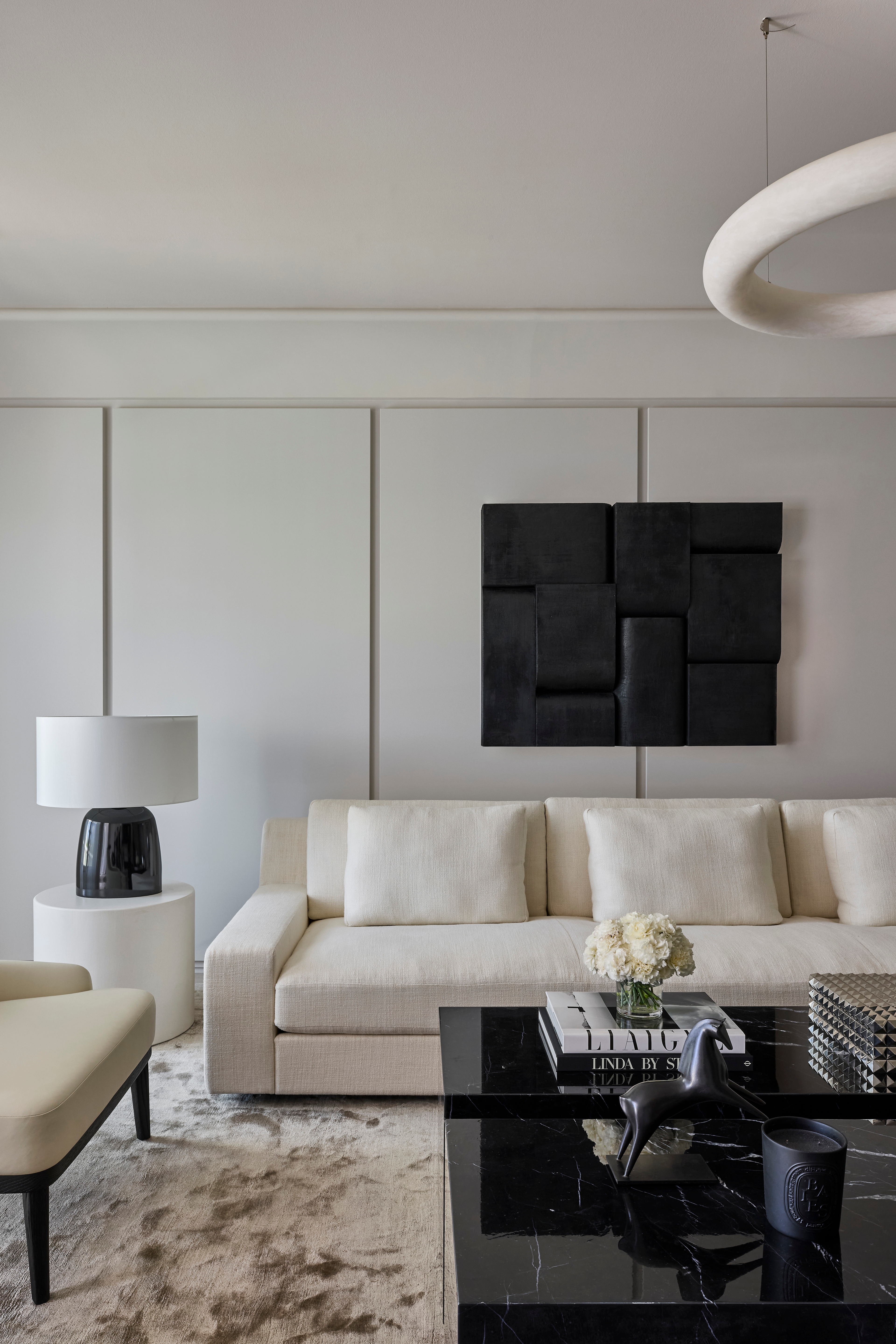 Vincent Van Duysen living room with an ivory sofa and abstract black wall relief