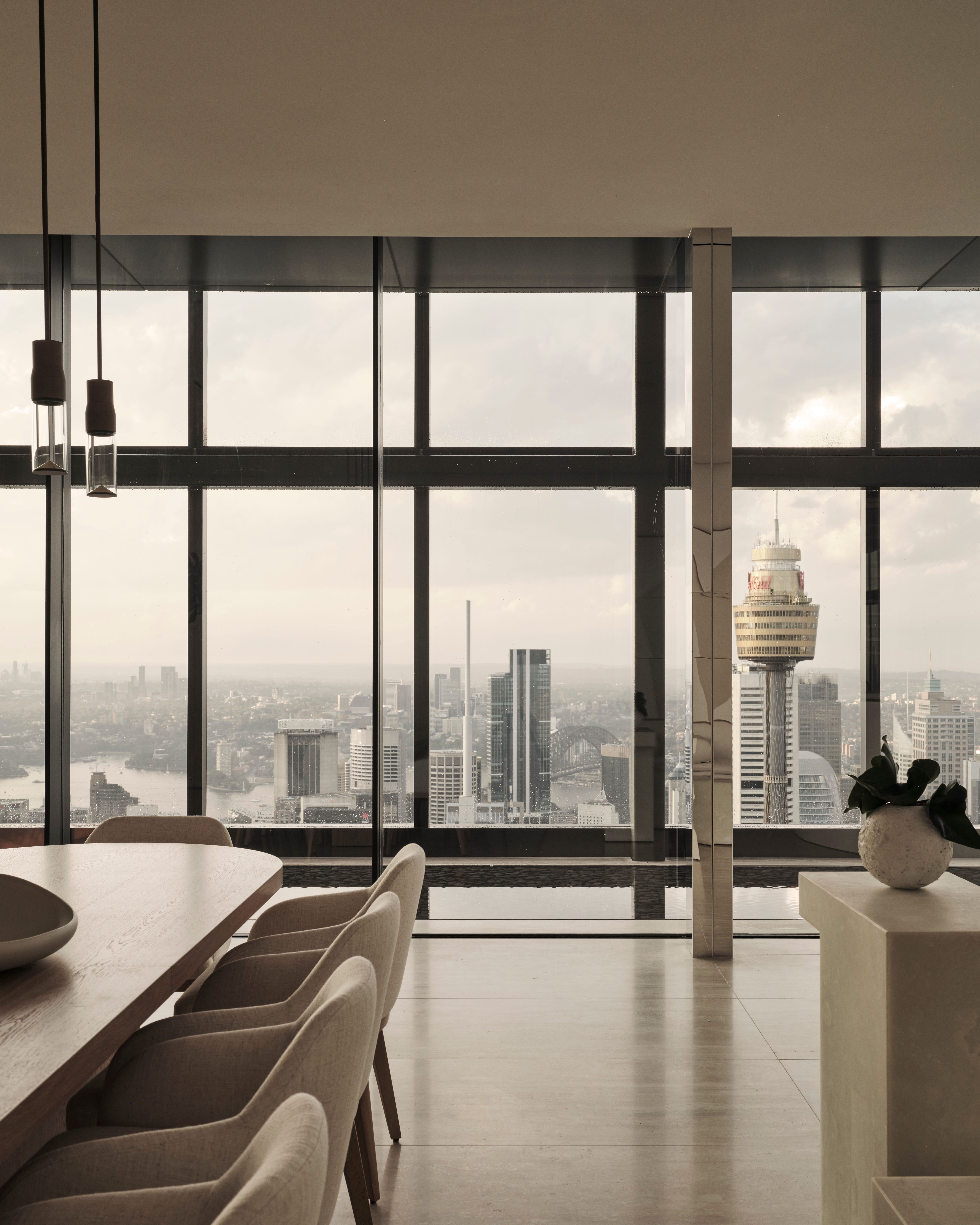 Sky-high dining room framing the Sydney Tower skyline, CBD residence
