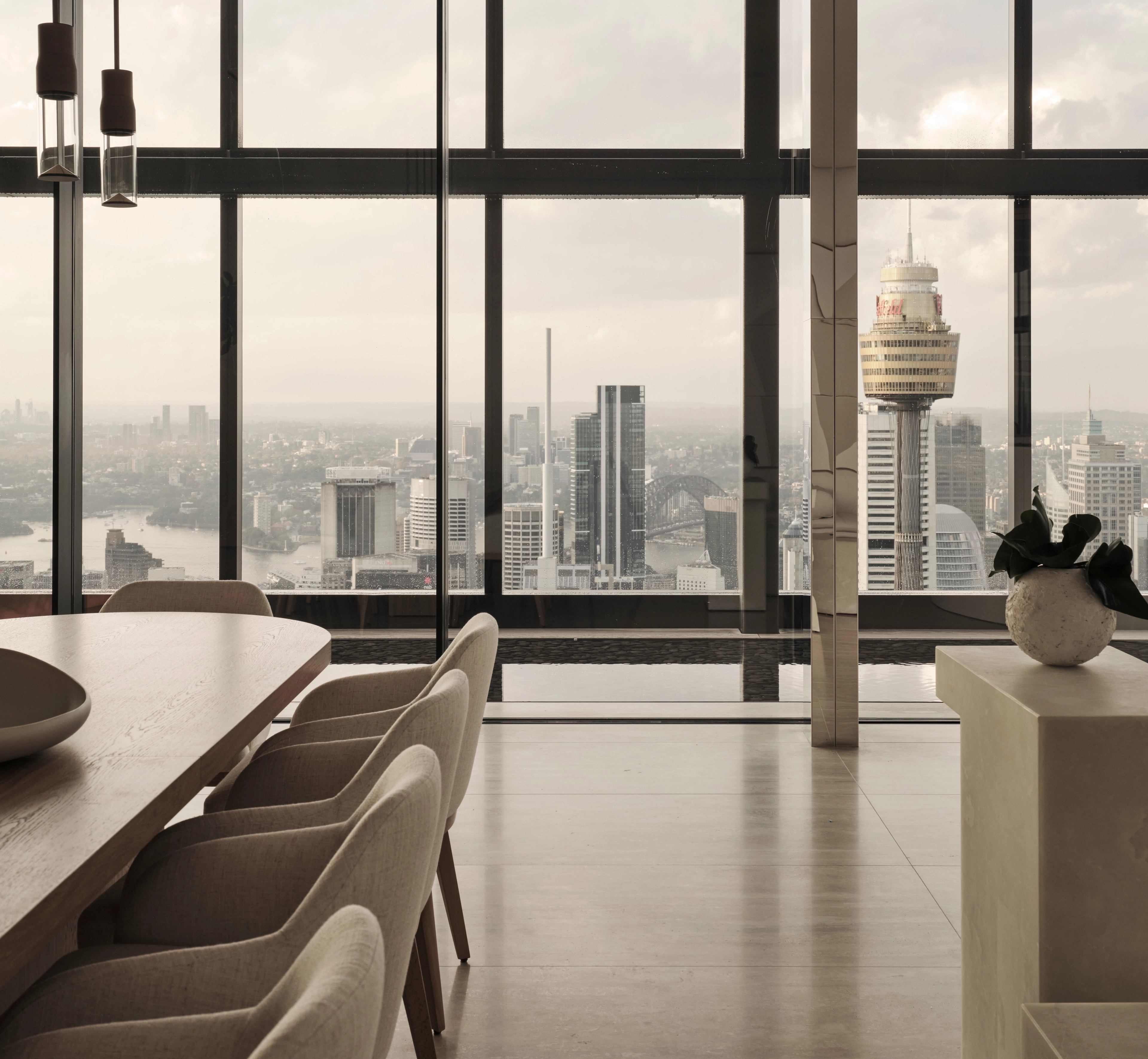 Sky-high dining room framing the Sydney Tower skyline, CBD residence