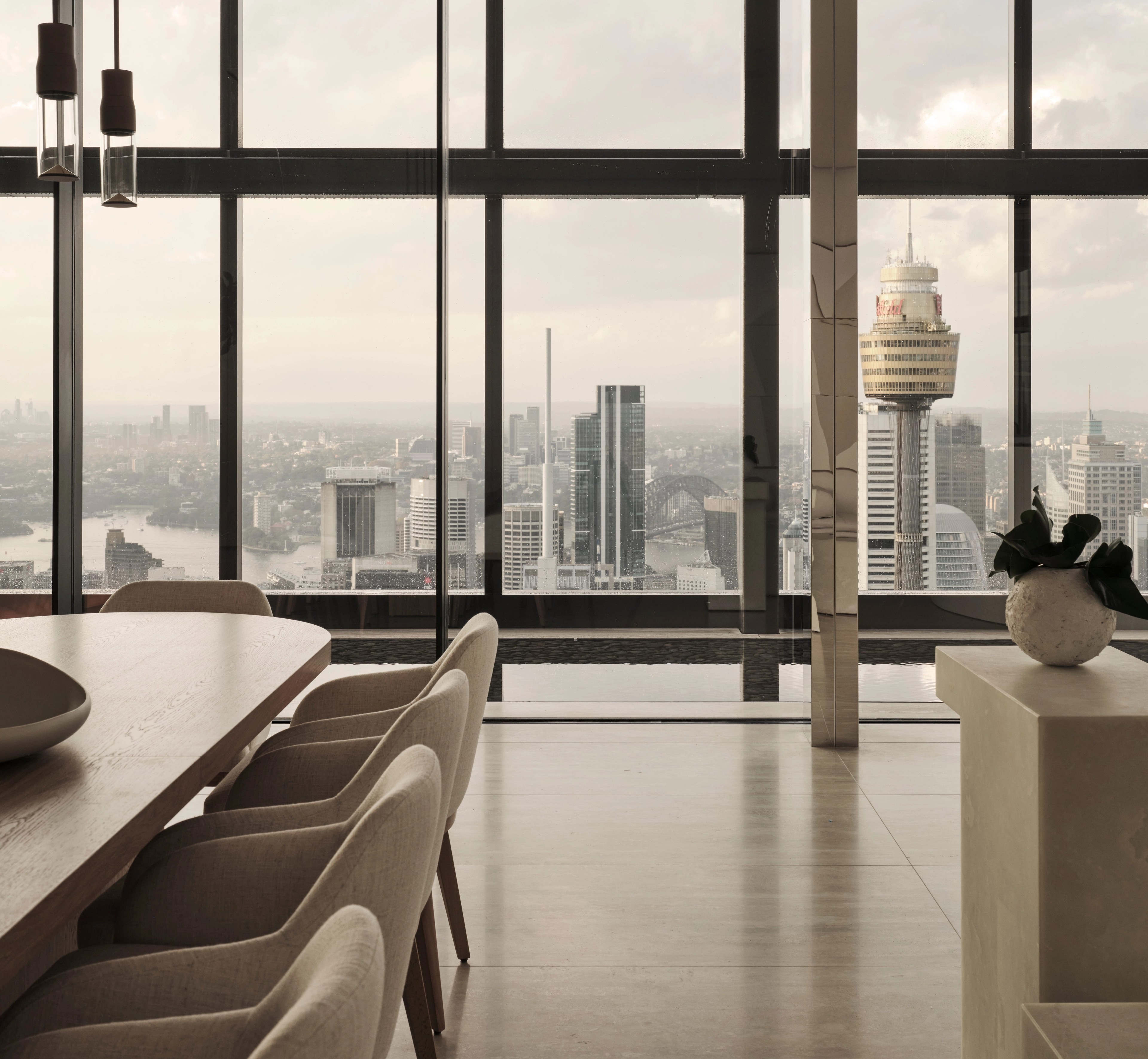 Sky-high dining room framing the Sydney Tower skyline, CBD residence