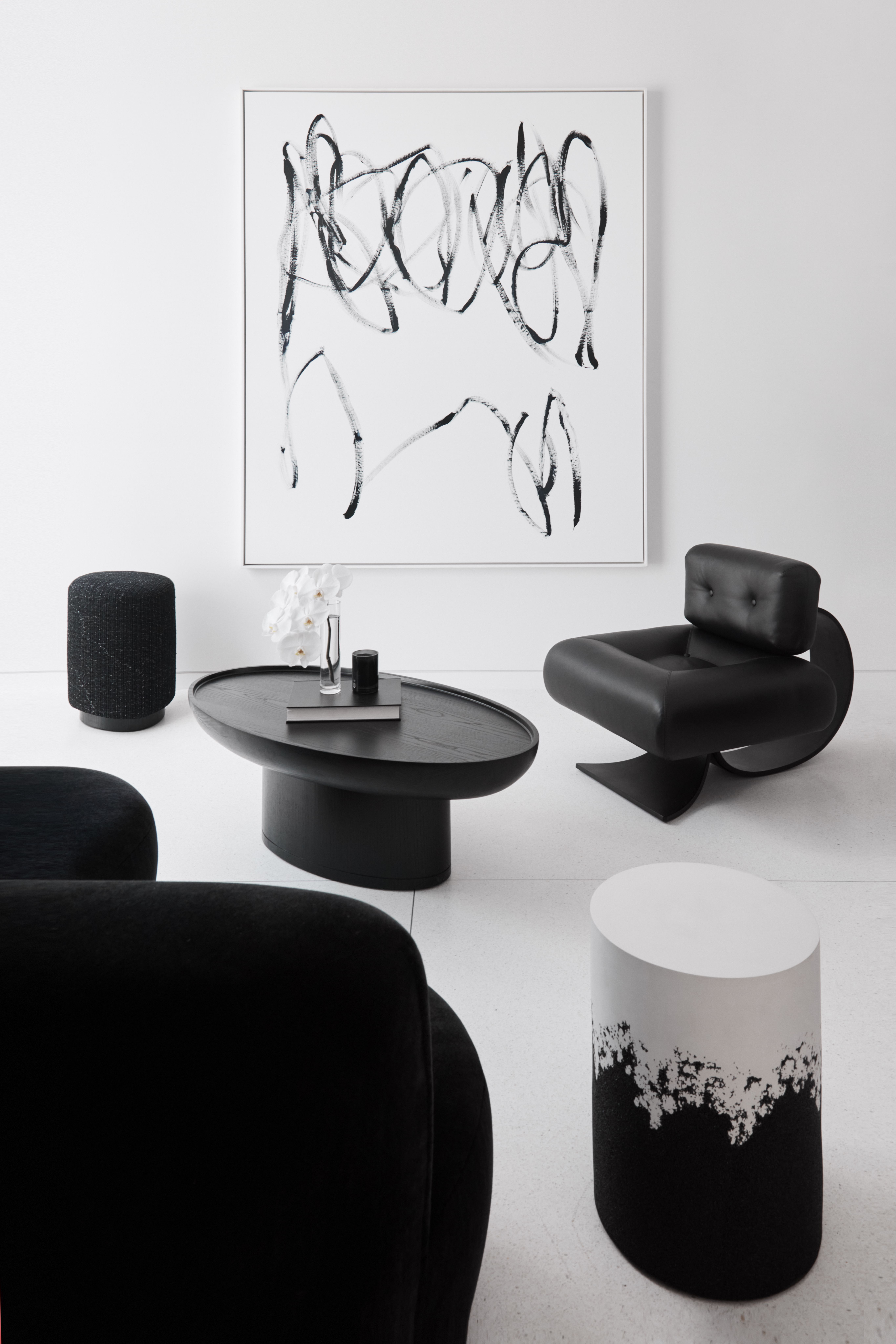 Curated monochrome interior by Freeman & Co with sculptural black seating and abstract artwork