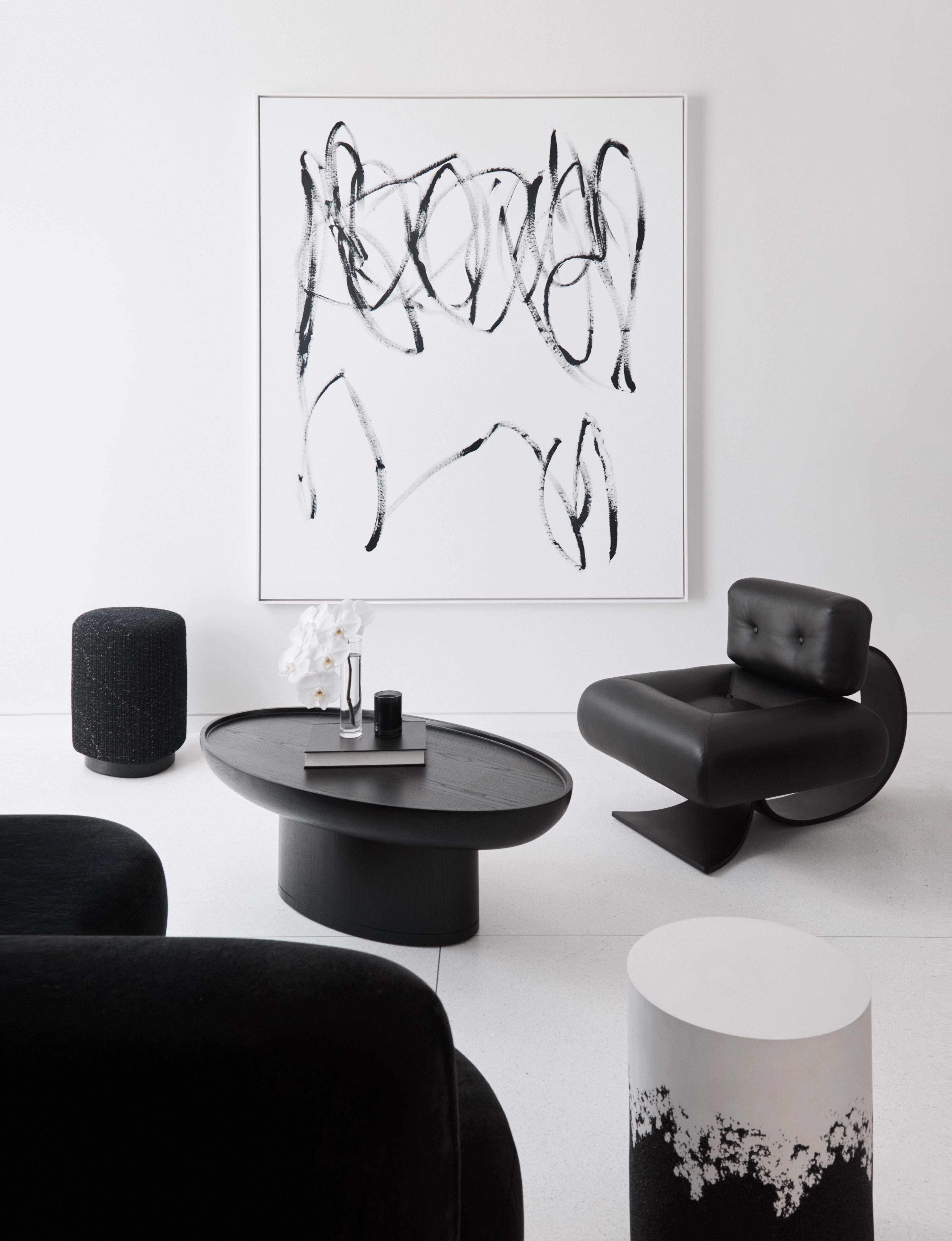 Curated monochrome interior by Freeman & Co with sculptural black seating and abstract artwork