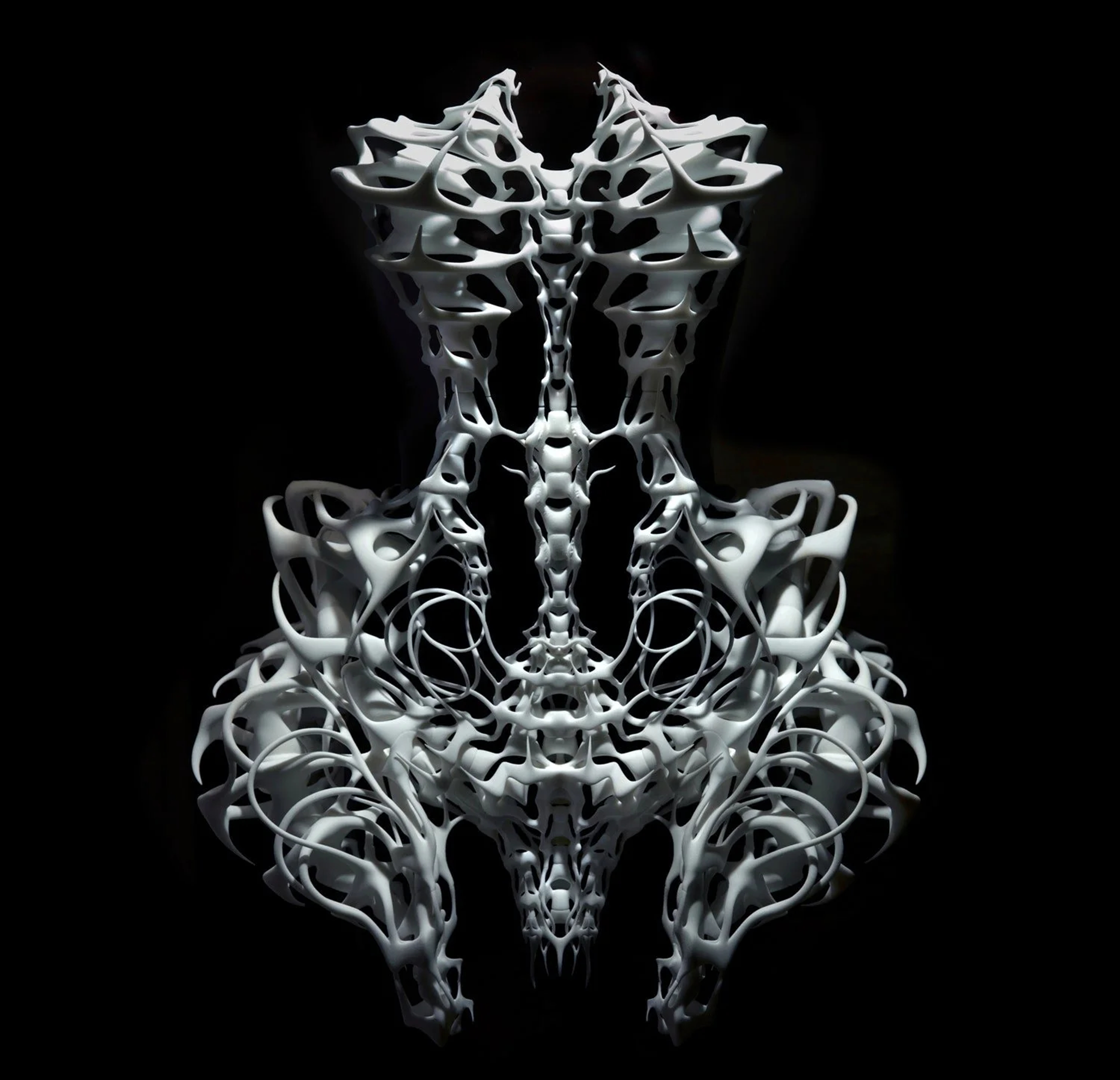 Intricate skeletal filigree form suspended against black, echoing Iris van Herpen's craft