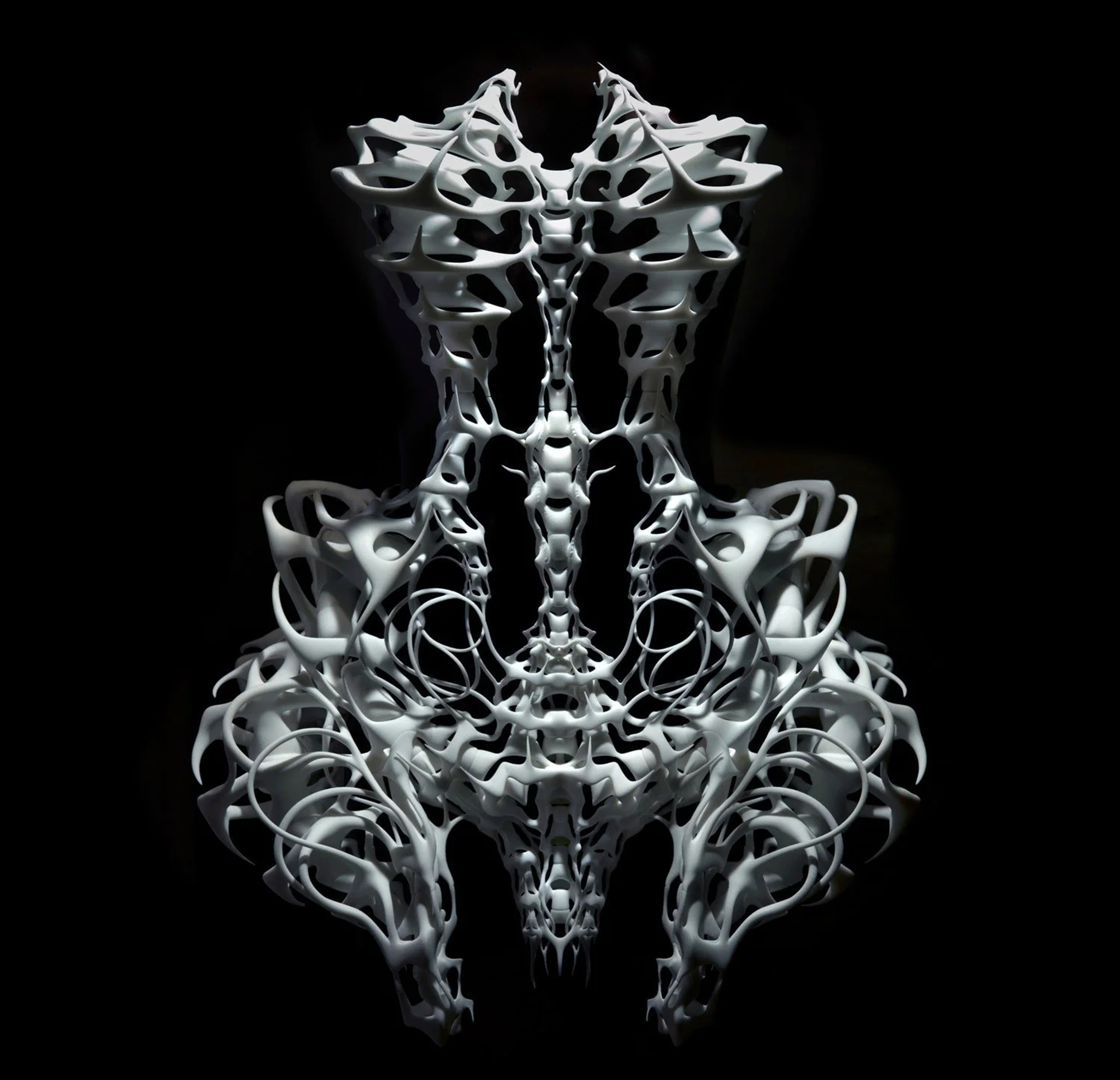 Intricate skeletal filigree form suspended against black, echoing Iris van Herpen's craft
