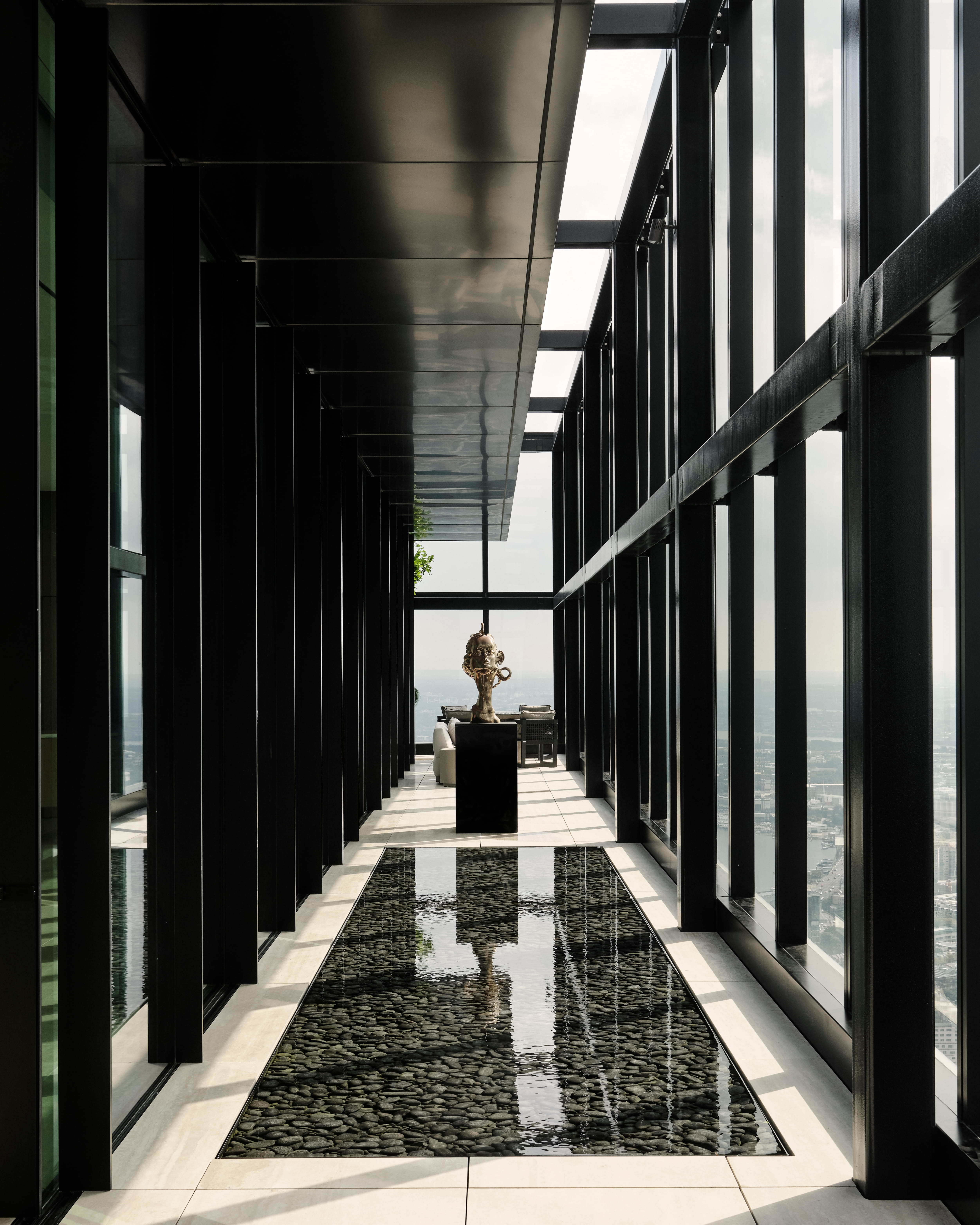 Mirror-clad corridor reflecting a lone plinth-mounted sculpture toward the light, Sydney CBD
