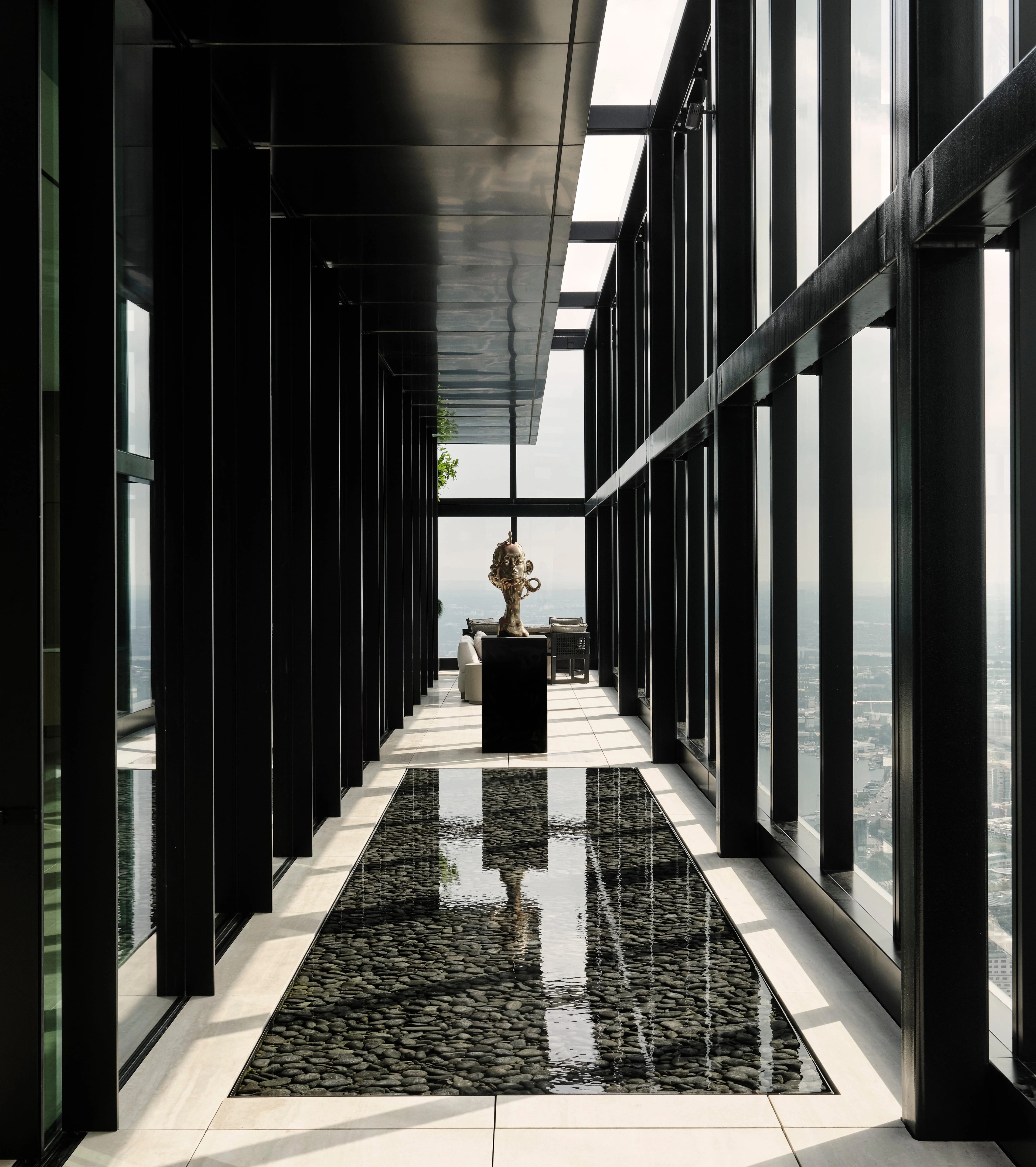 Mirror-clad corridor reflecting a lone plinth-mounted sculpture toward the light, Sydney CBD