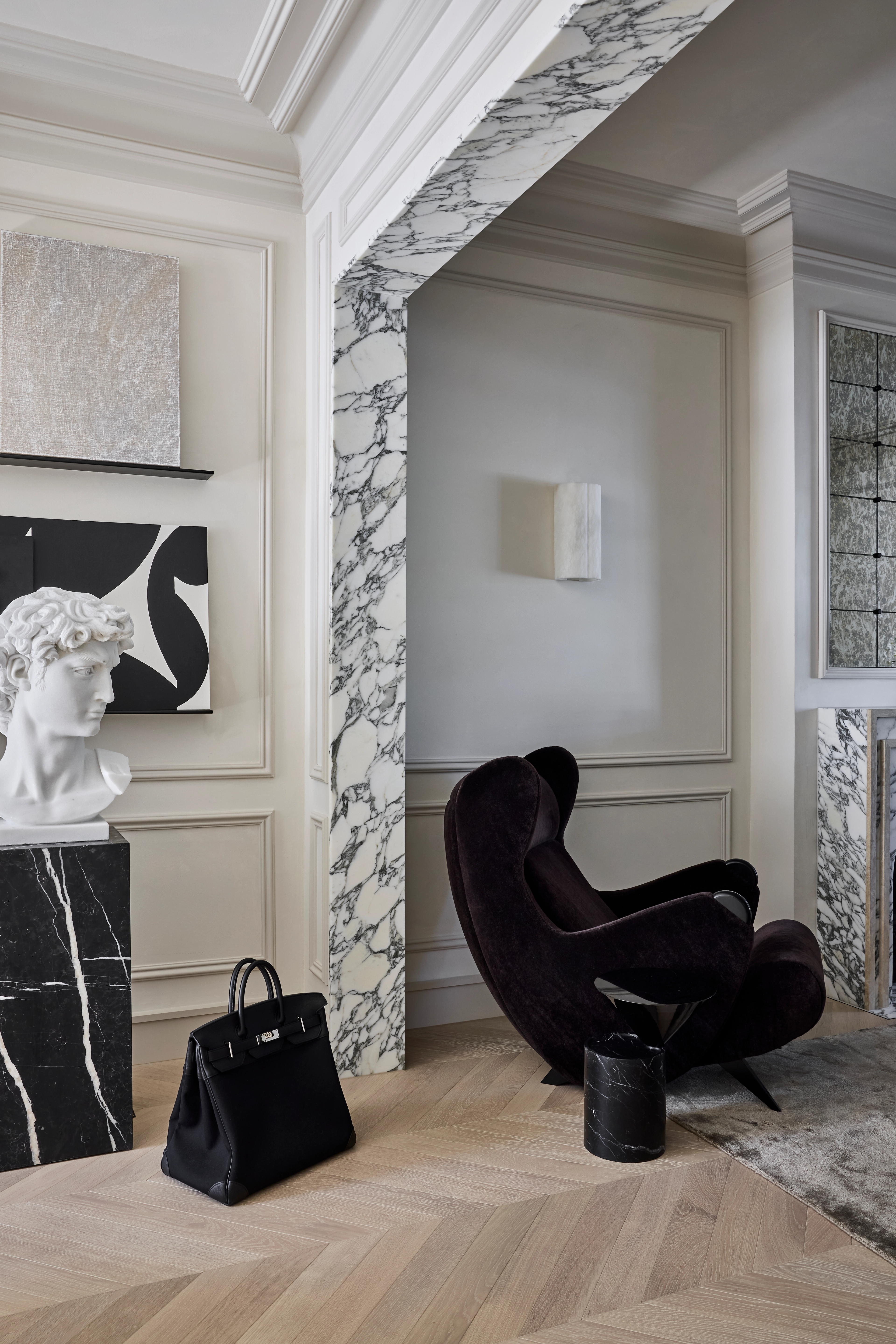 Refined Paddington room with a classical bust, dark velvet armchair and marble-framed passage