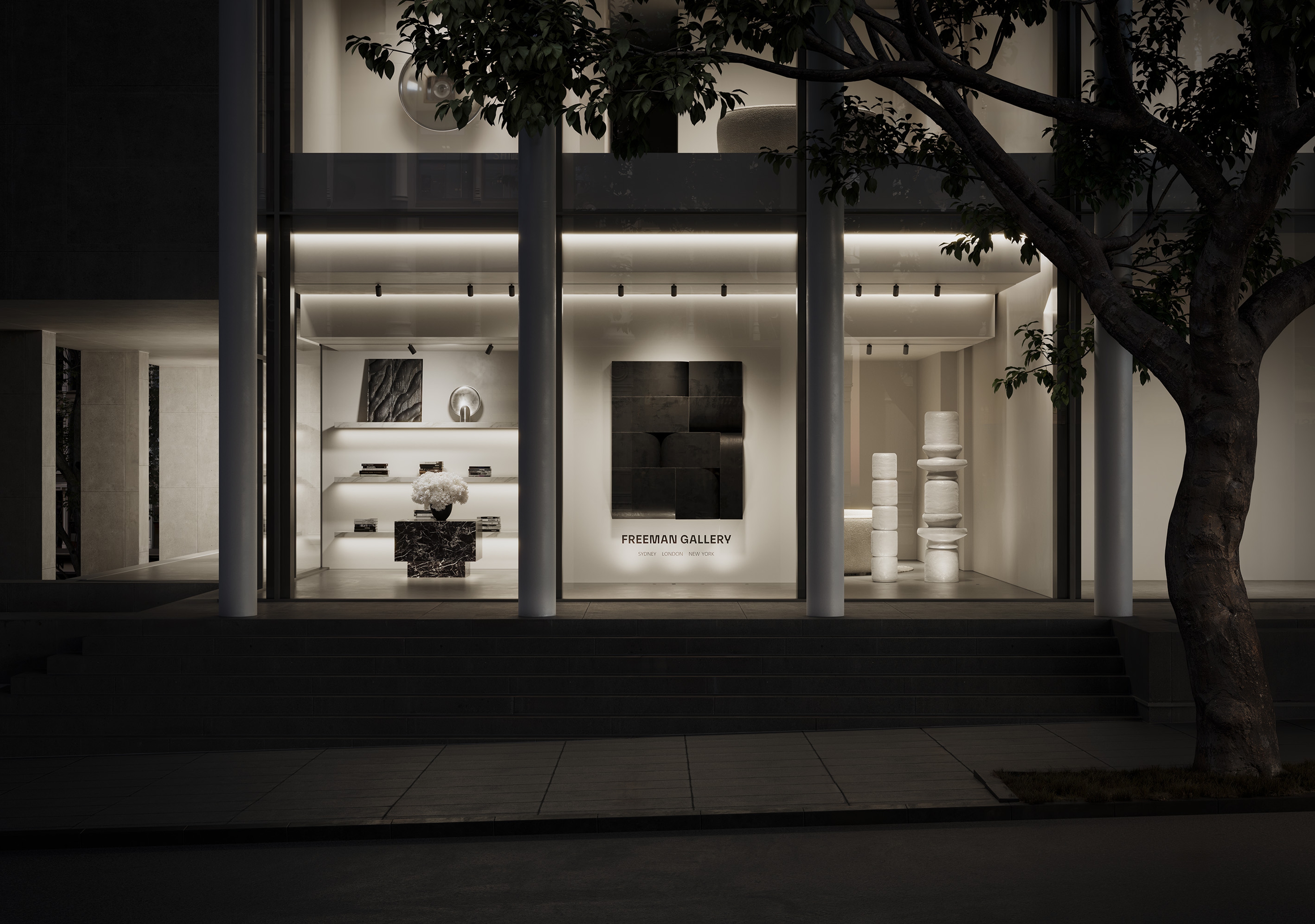 The Freeman Gallery at night, lit interiors and artwork visible through full-height glazing