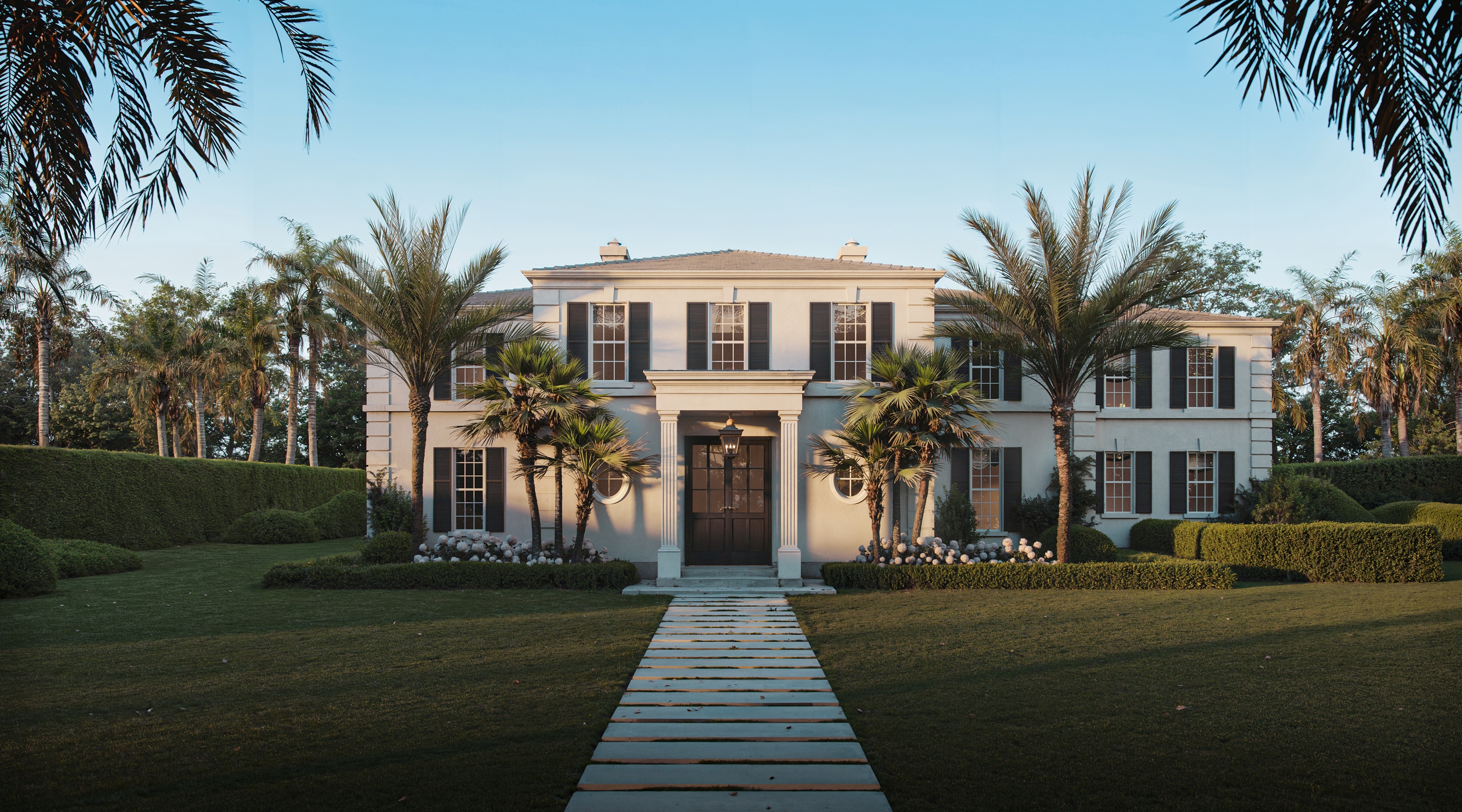 Georgian-inspired façade framed by tropical landscaping