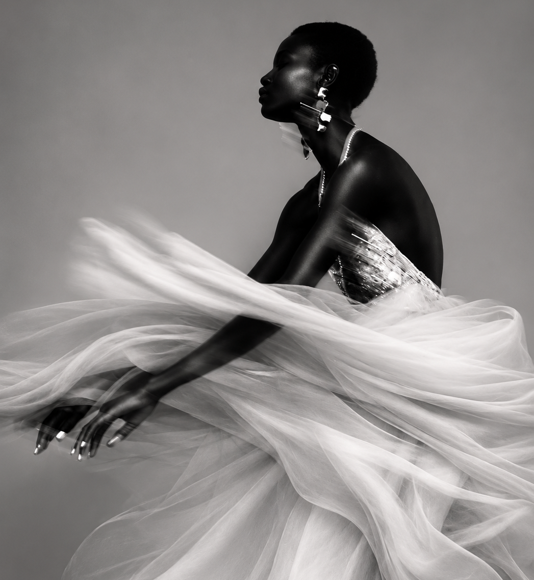 Sweeping black-and-white study of a woman swathed in billowing tulle, one arm extended