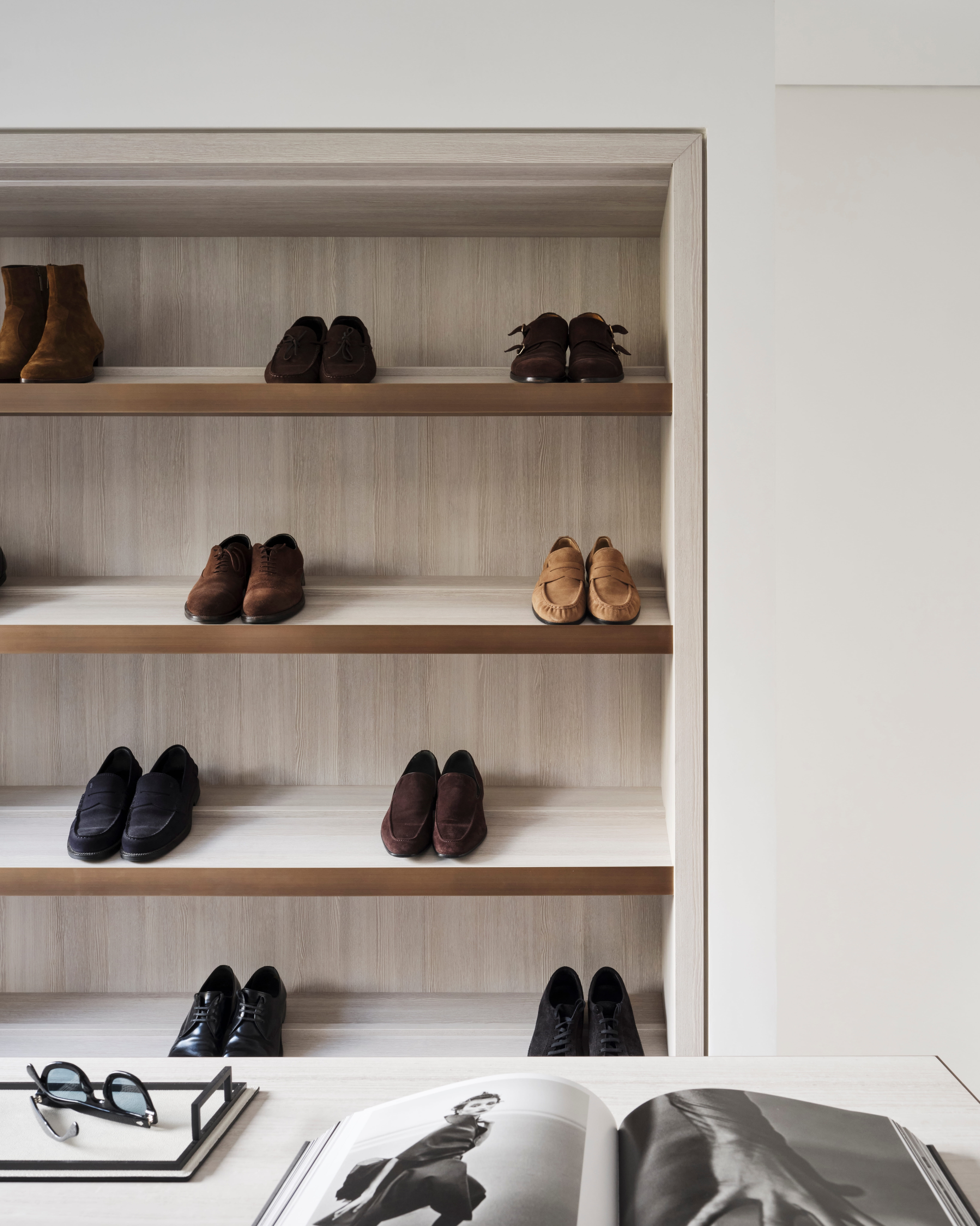 Open dressing room shelving in pale timber displaying men's shoes and boots, Elizabeth Bay