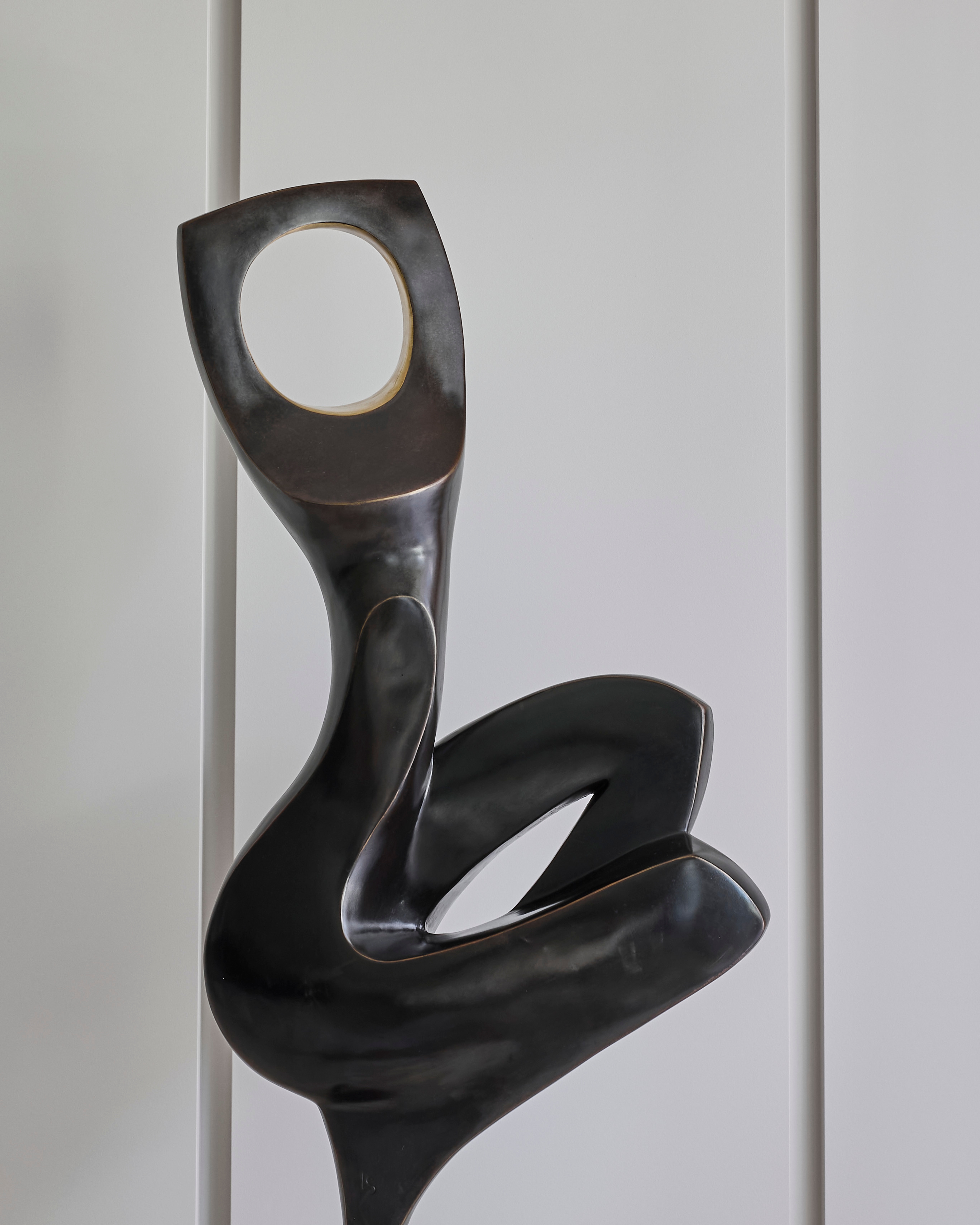Bronze biomorphic sculpture with a circular void, a sculptural focal point at Vaucluse