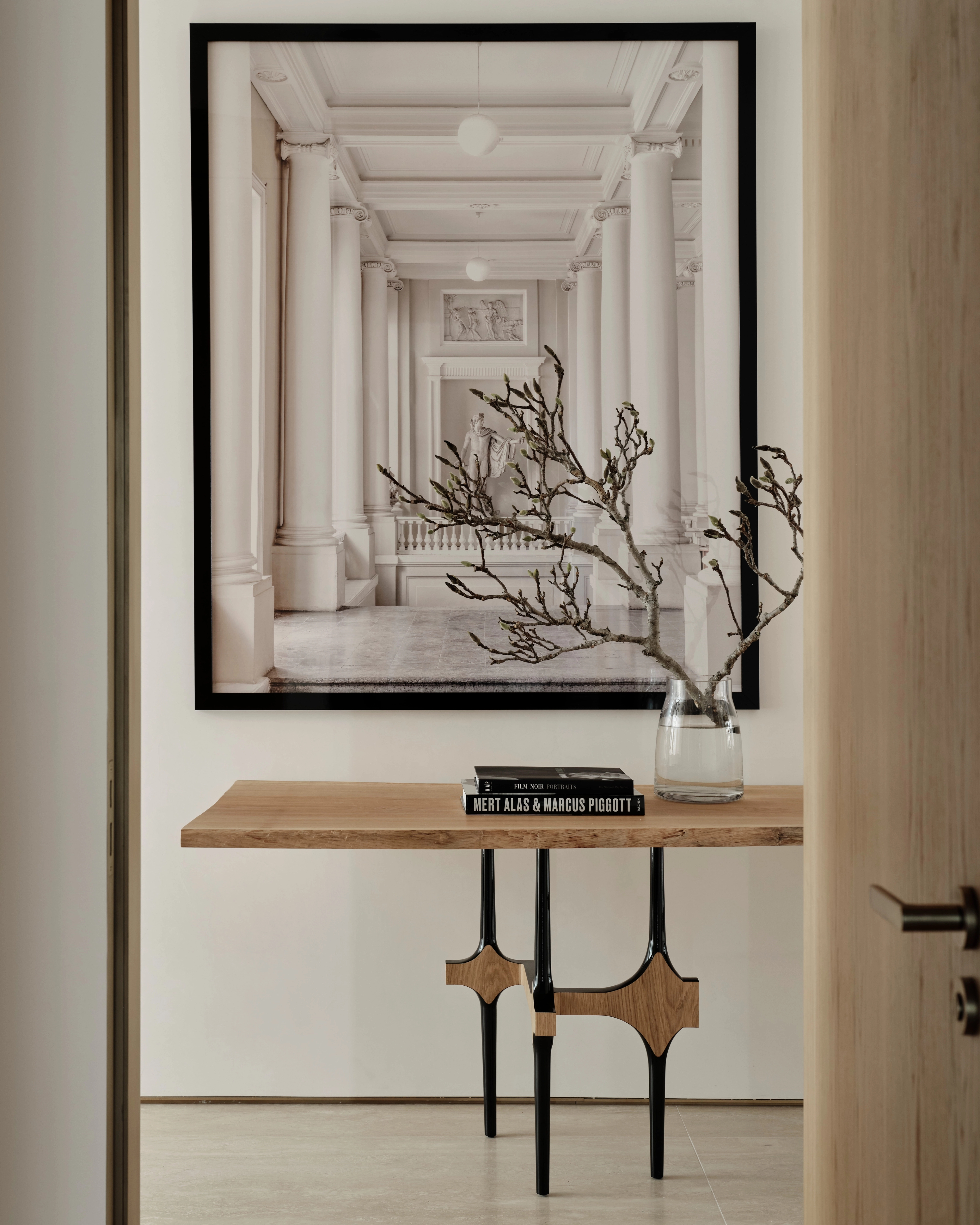 Console styled with bare branches and a framed colonnade photograph in a Sydney CBD residence
