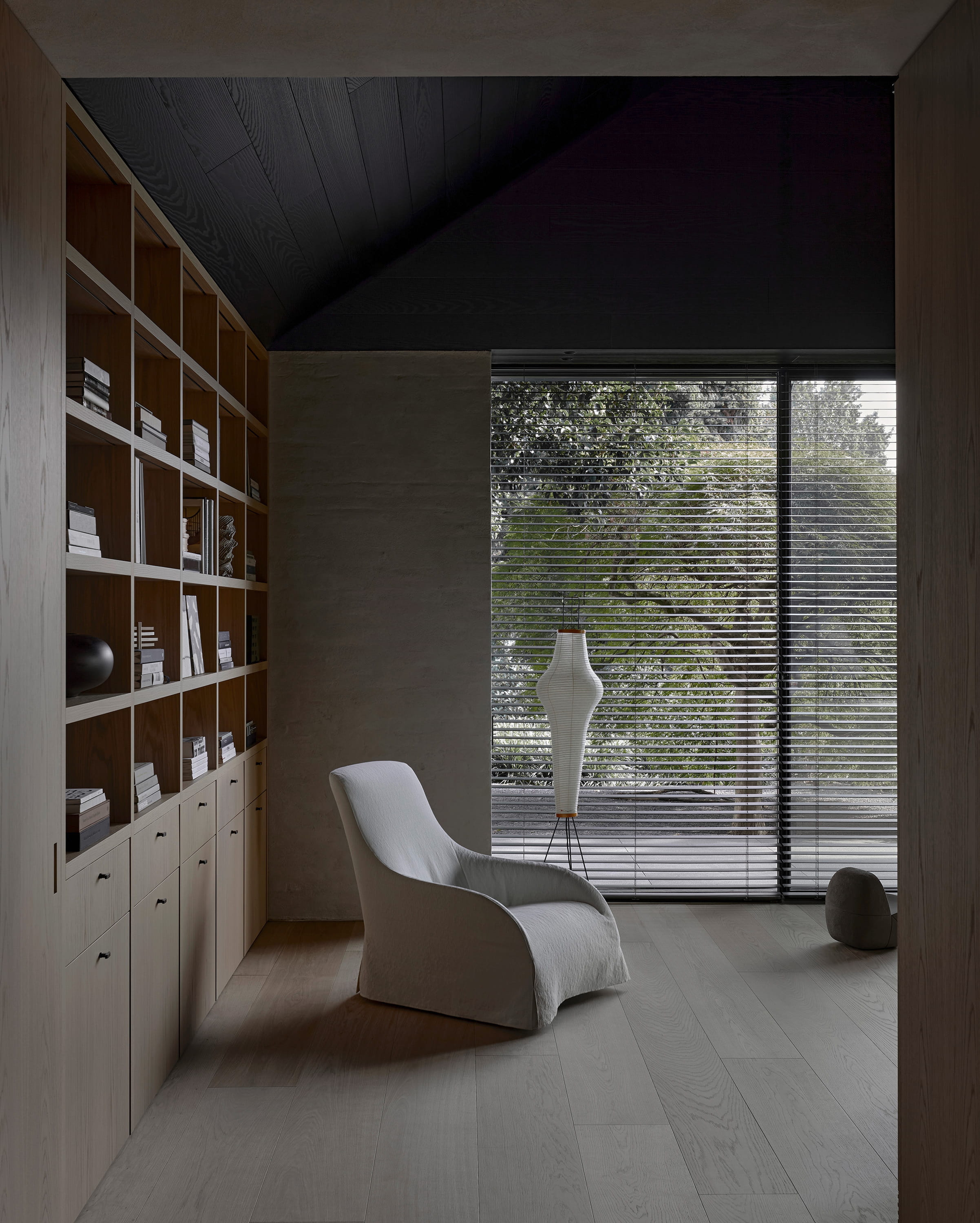 Warm timber-lined library with sculptural seating in a residence by architect Vincent Van Duysen