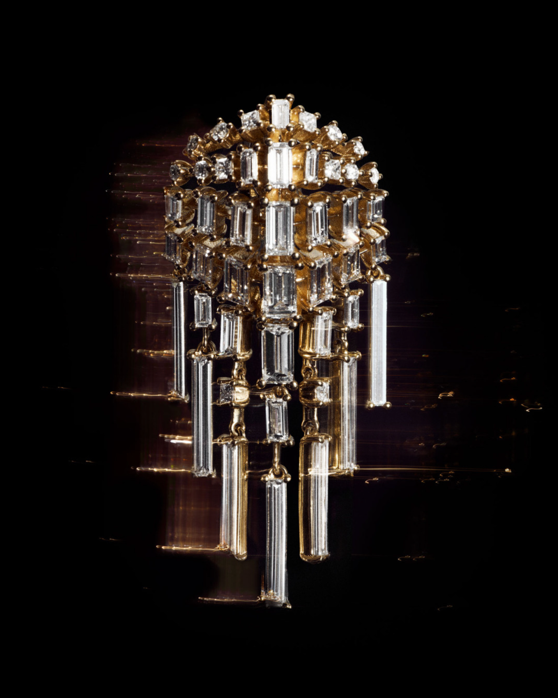 Glittering gold-and-crystal jewelled form suspended against a black background