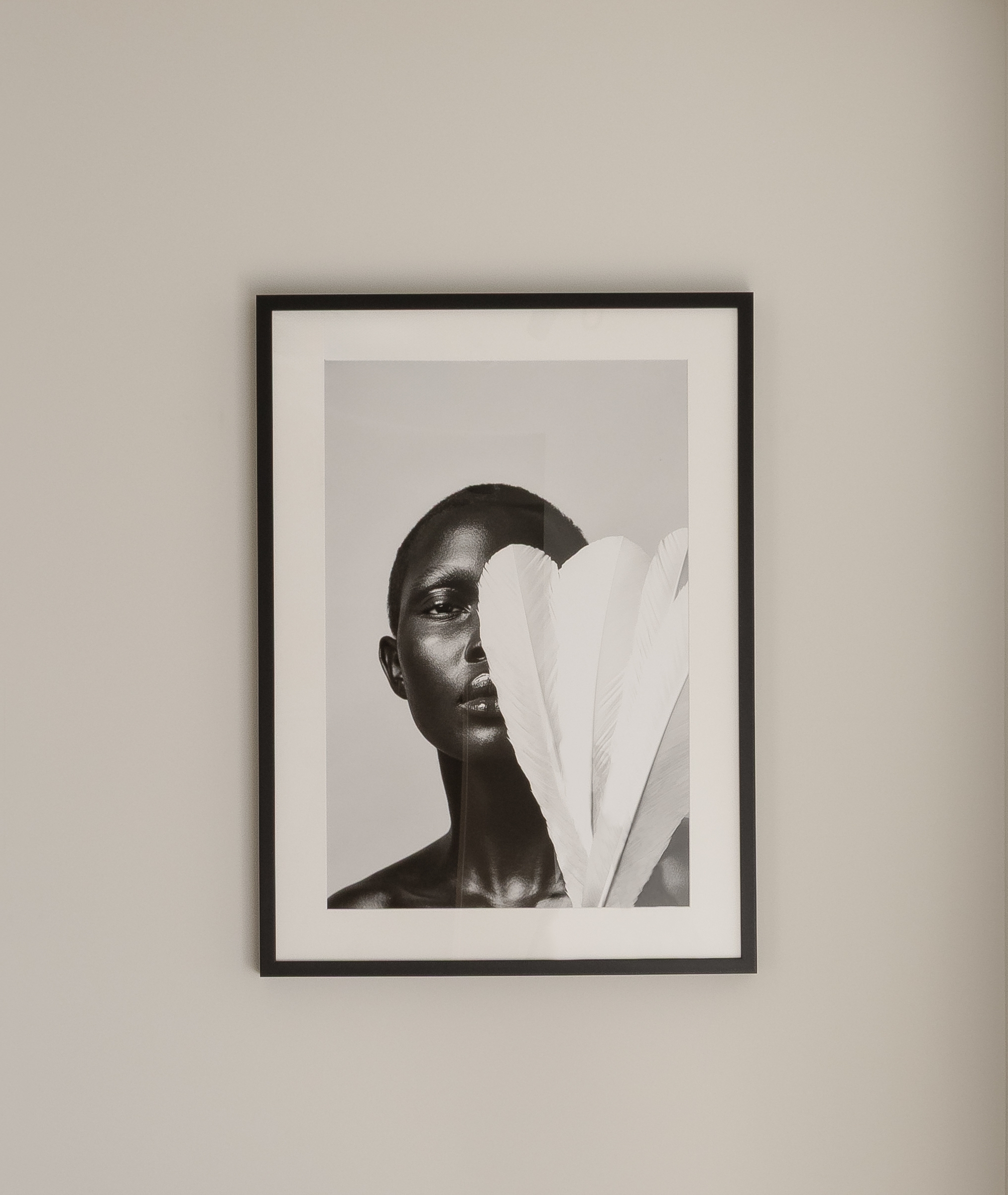 Serene corridor leading to a framed artwork above a slender black chair